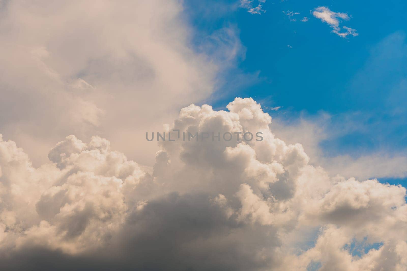 Sky with huge white clouds in spring on a sunny day. Huge white clouds on the sunny day background