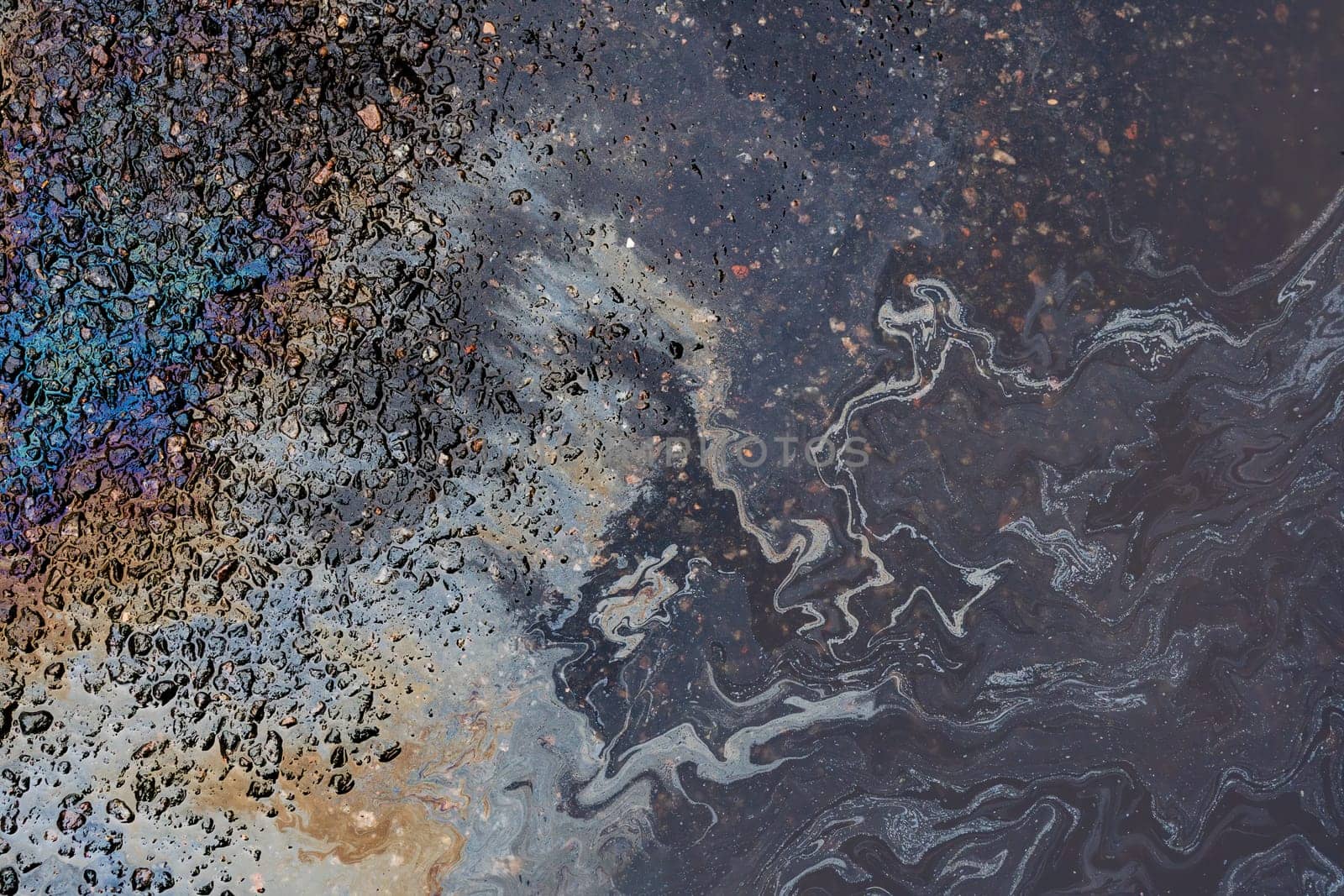 Abstract background from motor oil, gas or petrol spilled on asphalt.
