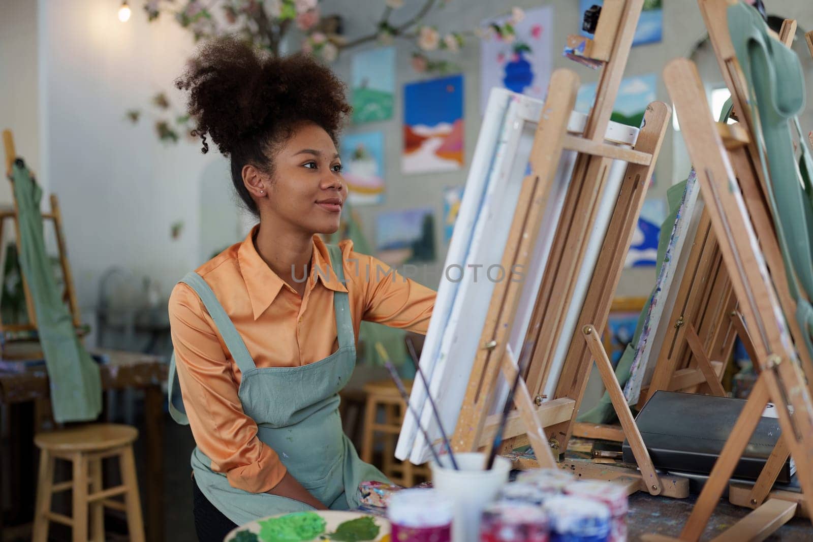 Beautiful american african artist woman painting in art studio at the university classroom by itchaznong