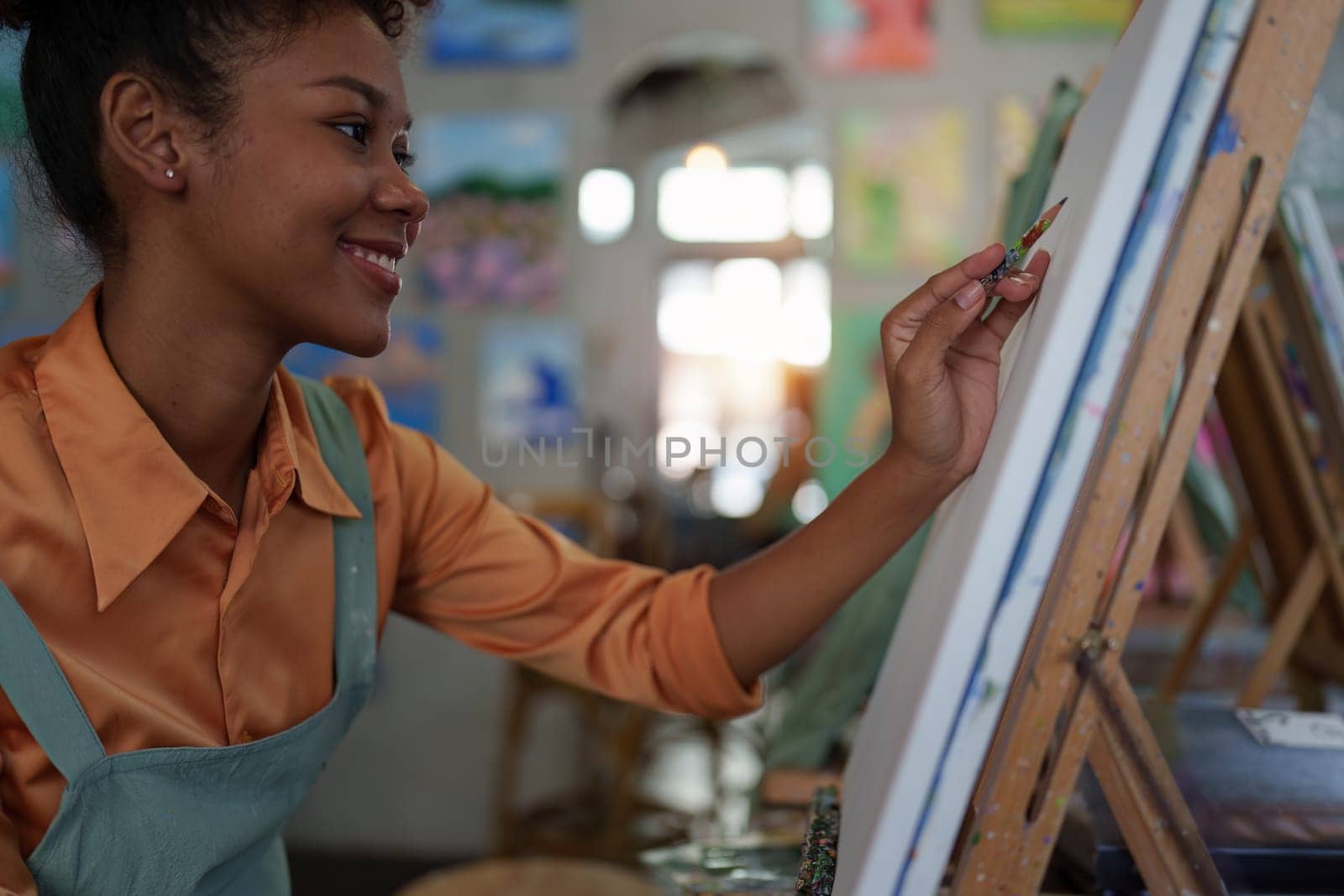 Beautiful american african artist woman painting in art studio at the university classroom by itchaznong