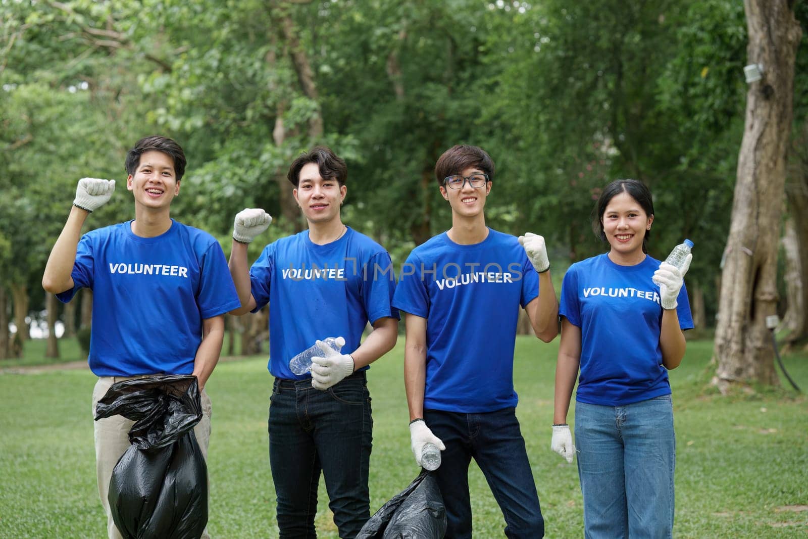 Young Asian Volunteers with garbage bags cleaning park area. Ecology, Charitable organization concept by itchaznong