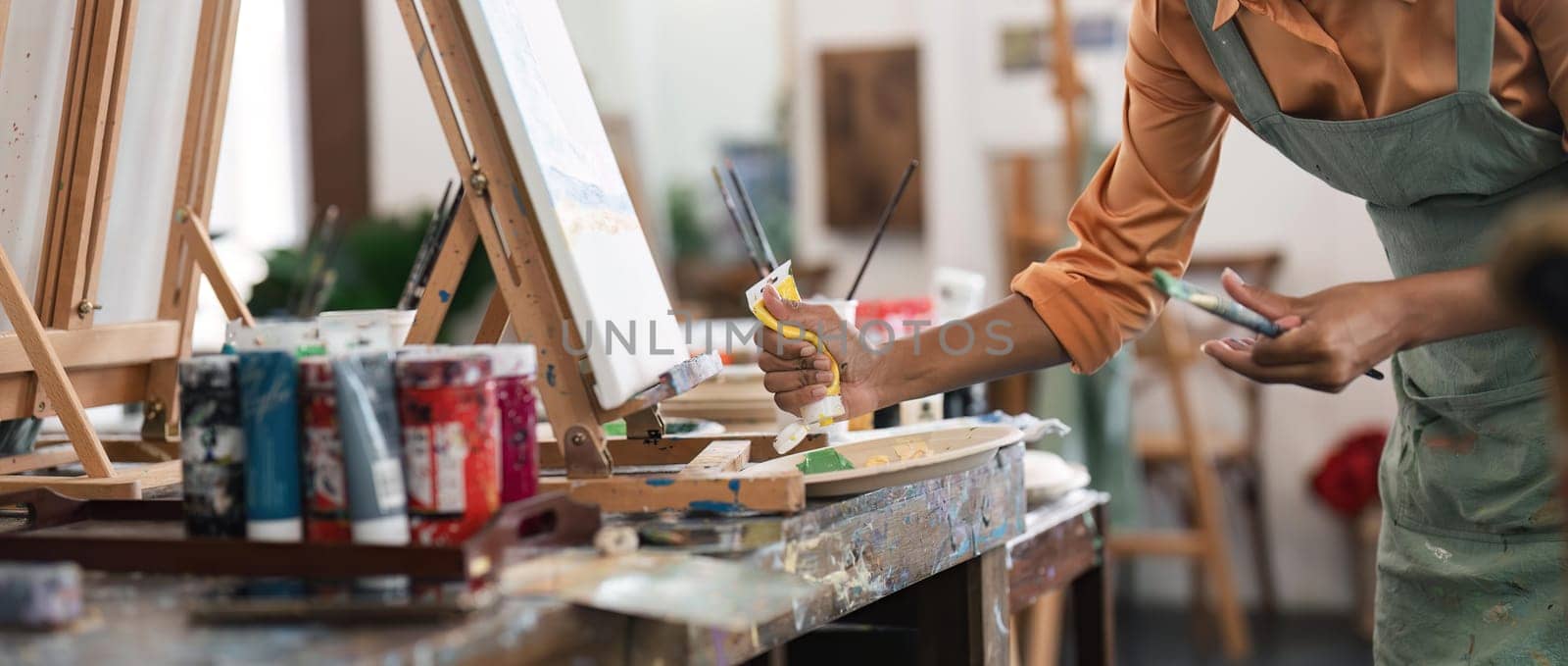 Close up portrait of beautiful african american and authentic young female artist or painter create art piece. Detailed work for personal creative project.