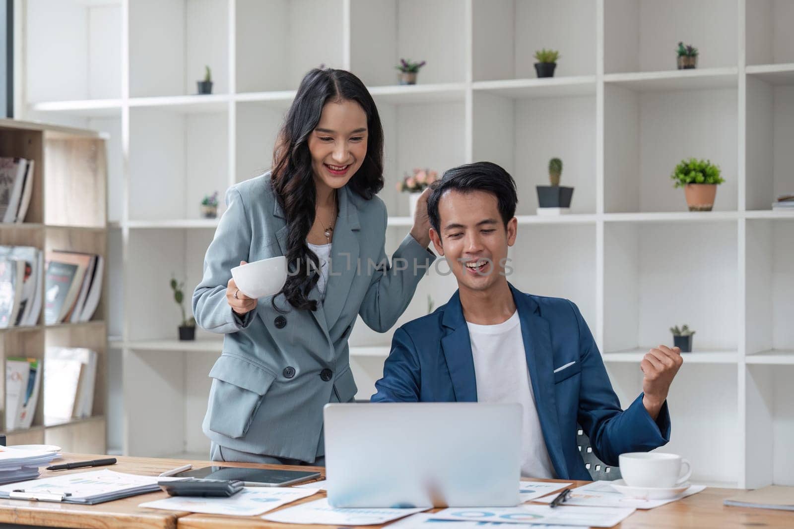 Business strategy success. Overjoyed colleagues emotionally celebrating win, looking at laptop computer screen in office.