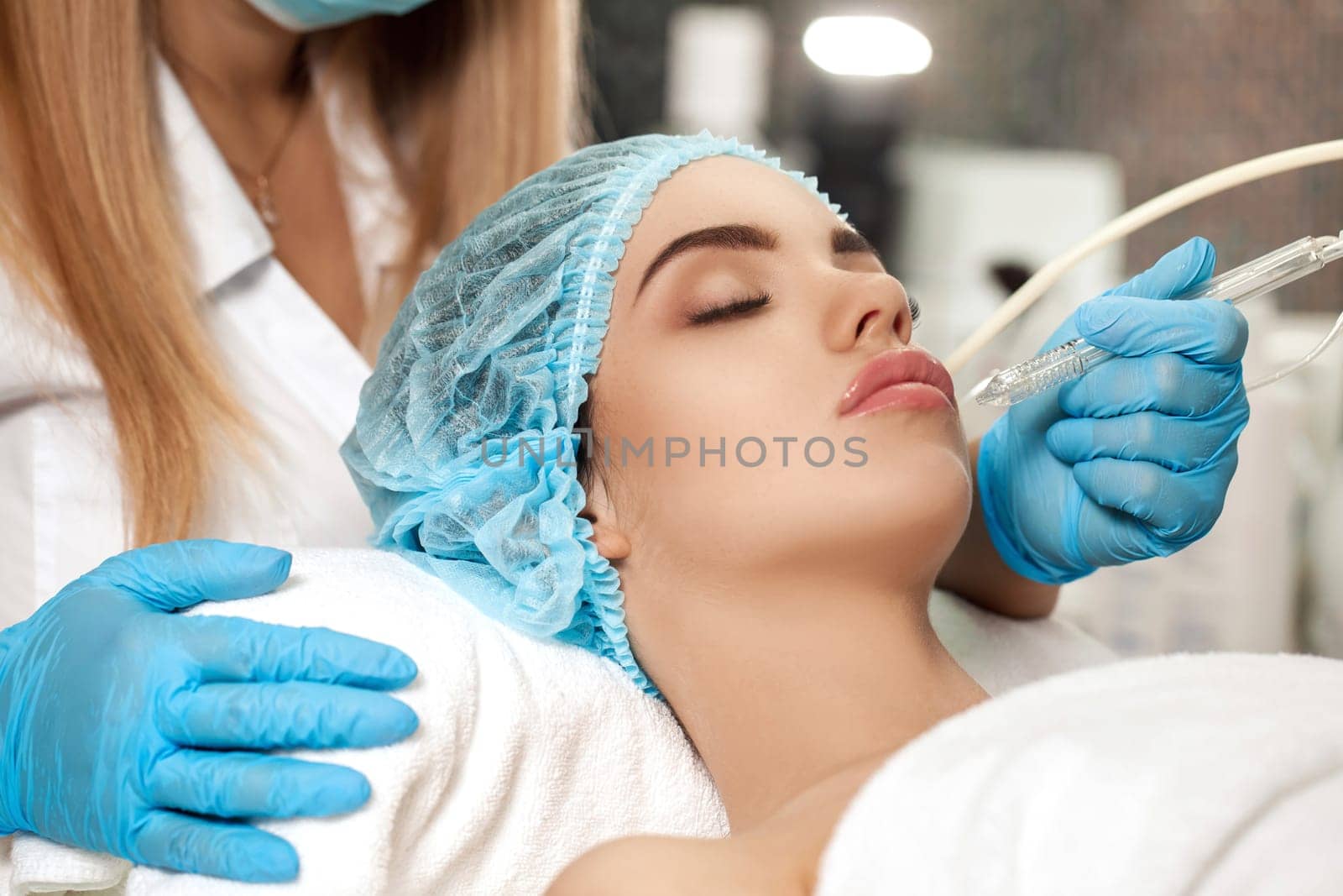 Beautician makes Ultrasonic cleaning of the face in spa salon. cosmetology
