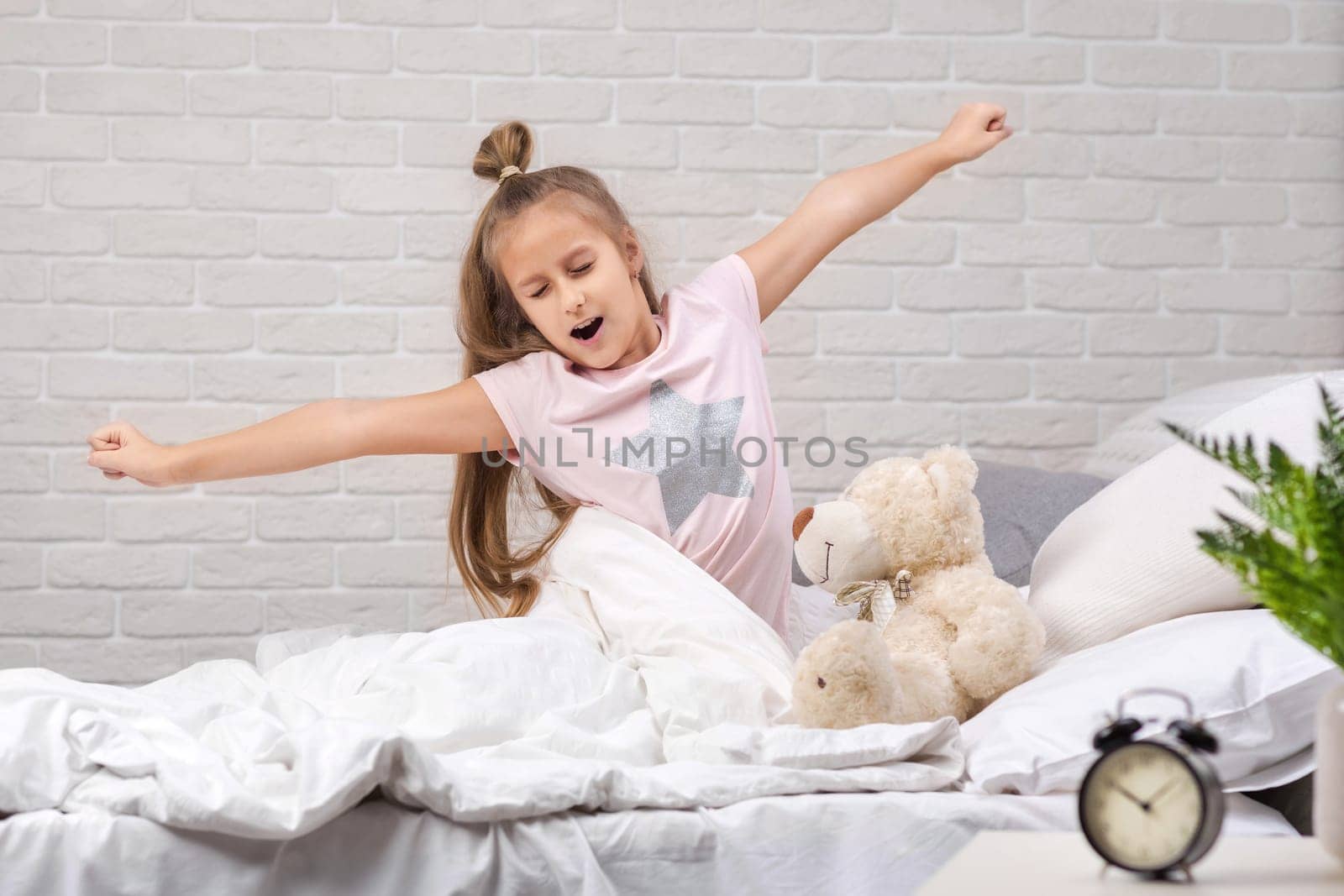 cute little child girl wakes up from sleep in bed in the morning