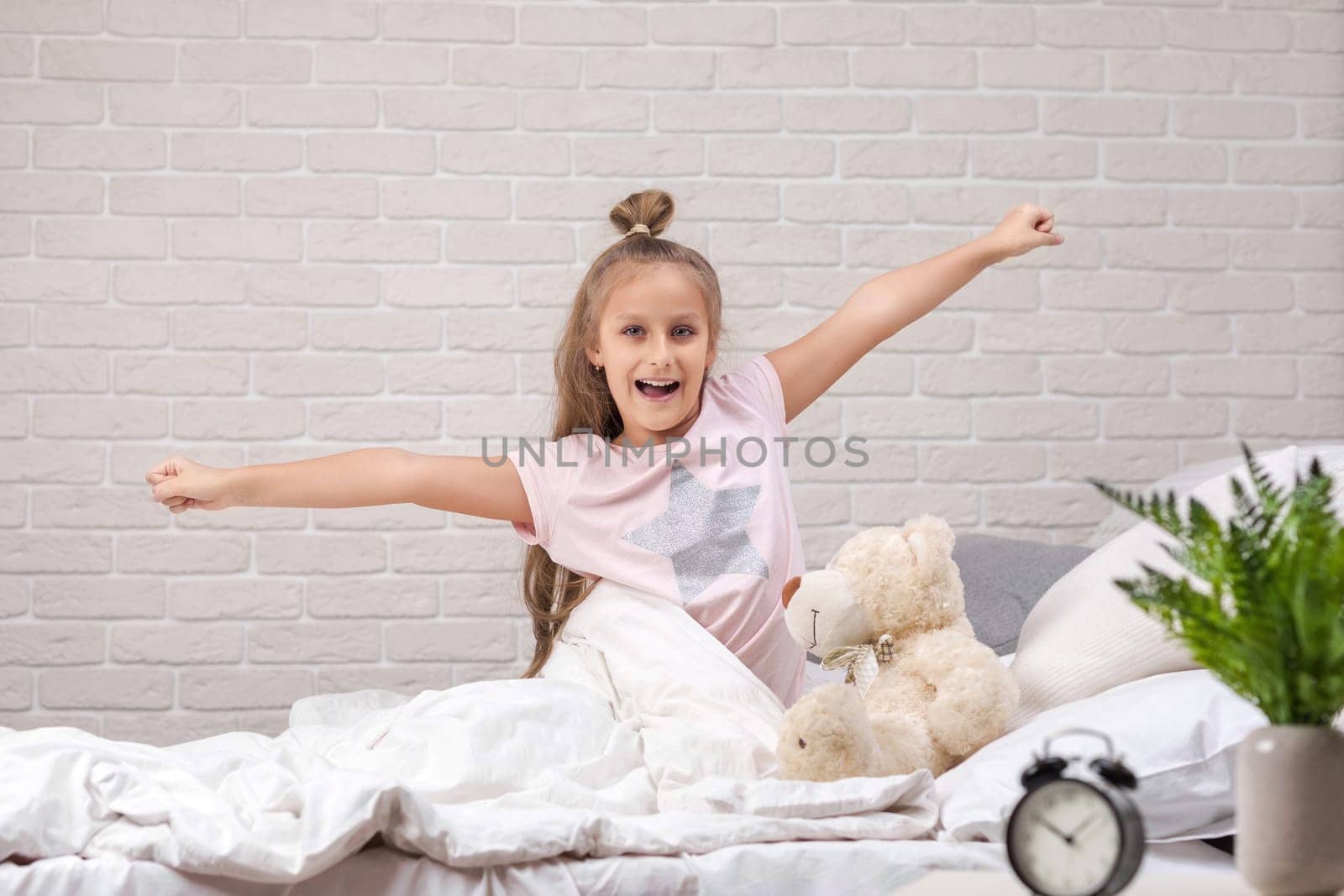 cute little child girl wakes up from sleep in bed in the morning