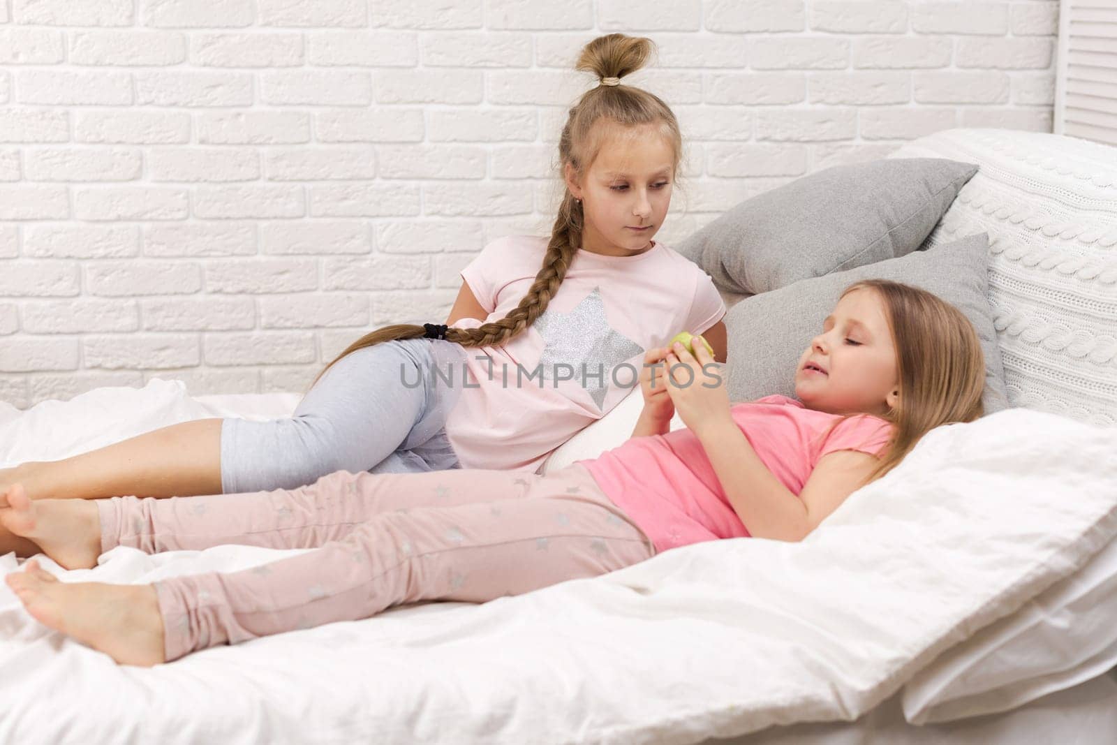 two cute children girls playing in the bedroom. pajama party and friendship.