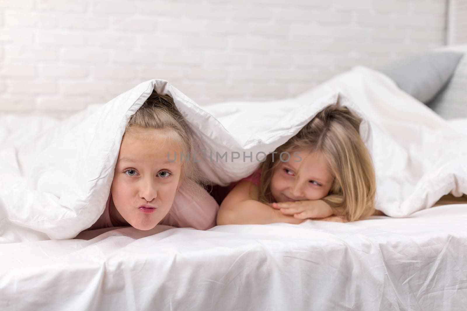 happy smiling morning kids in bed. children dabble in bed