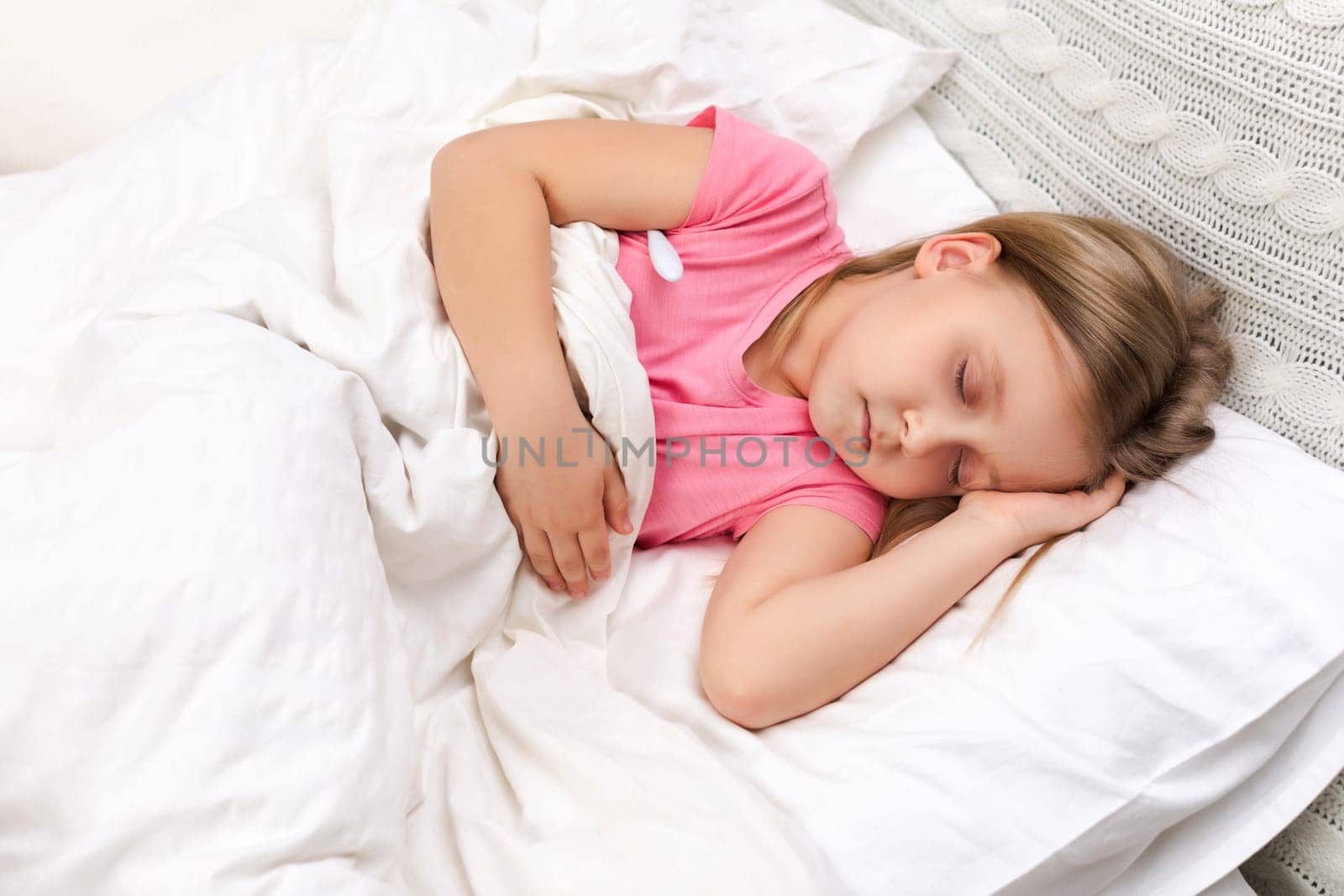 Sick little child girl lying in bed with thermometer. Cold flu season