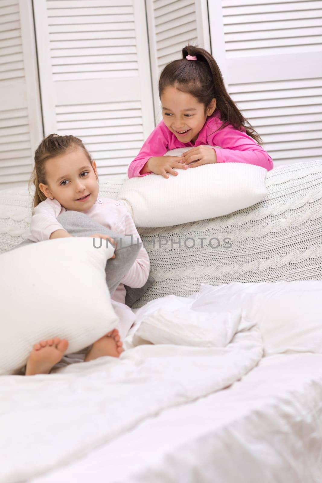 two cute children girls playing in the bedroom. pajama party and friendship.
