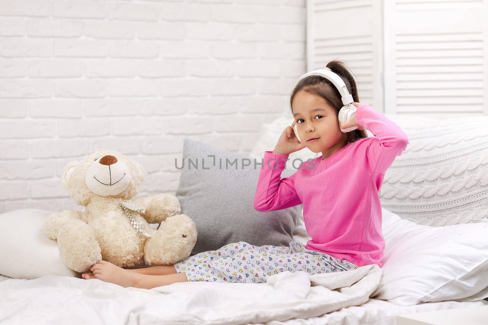 little child baby girl listening to the music with the headphones. happy morning