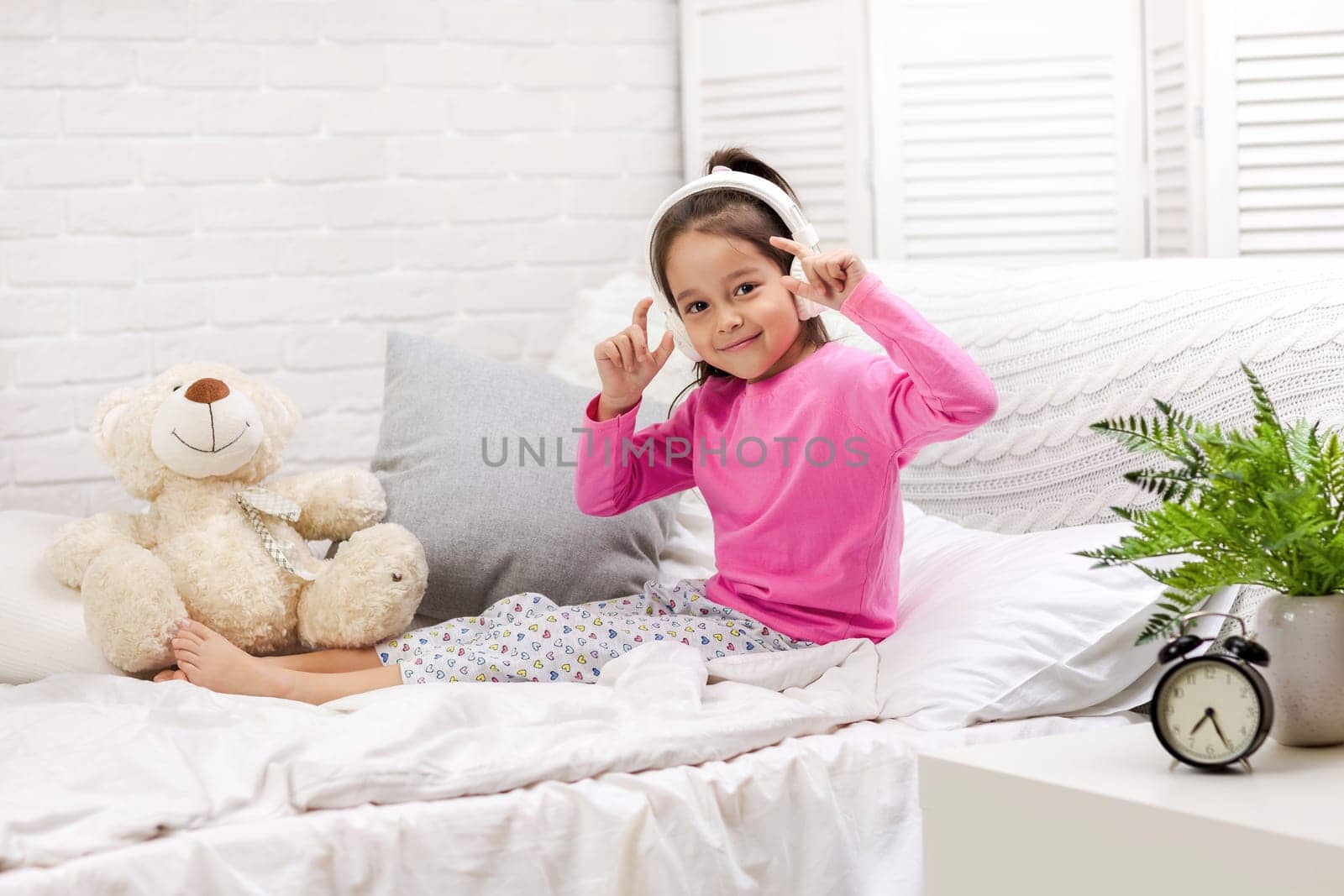 little child baby girl listening to the music with the headphones. happy morning