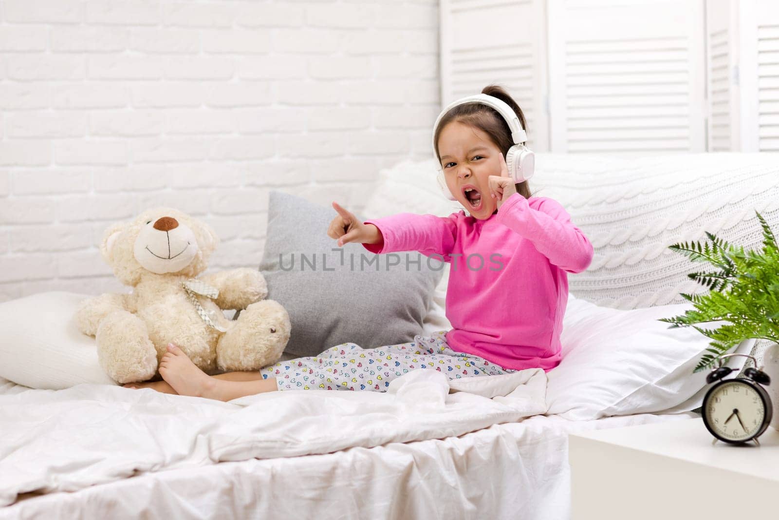 little child baby girl listening to the music with the headphones. happy morning