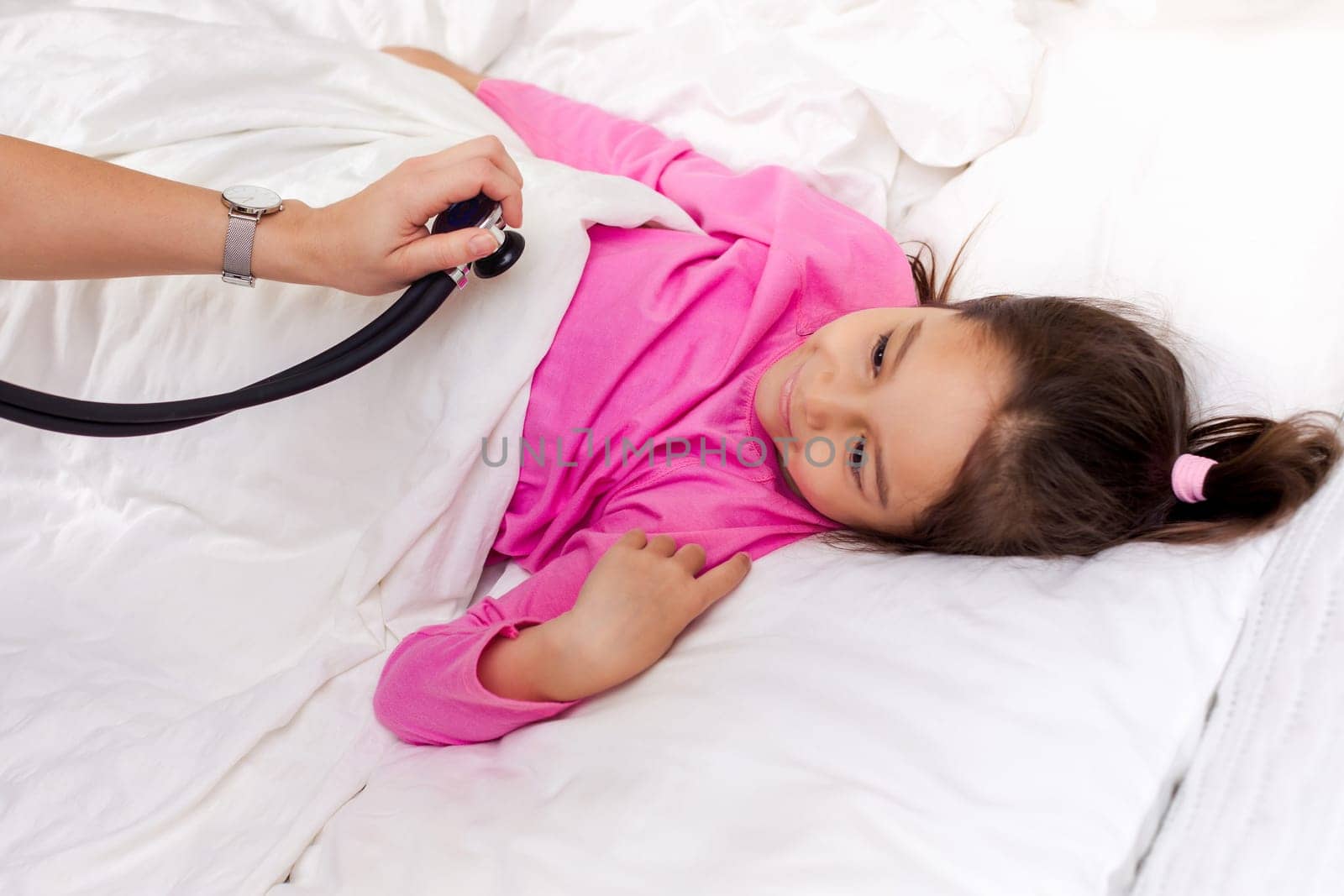 Pediatrician checks breath stethoscope a little girl