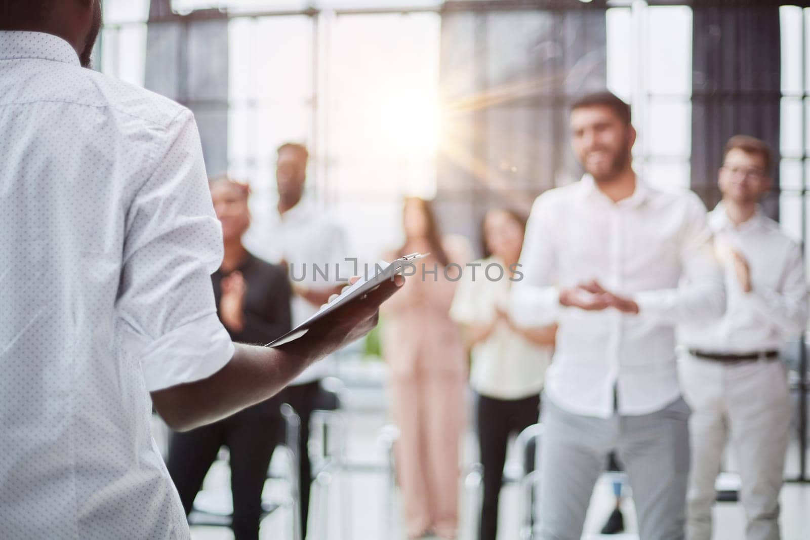 High angle view at multi-ethnic group of business people applauding standing up and smiling in audience at business conference or seminar