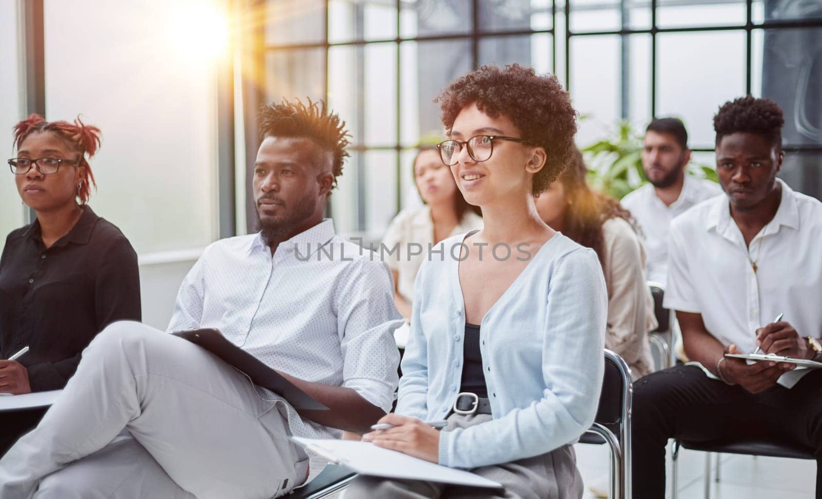 sitting in conference room near interracial colleagues