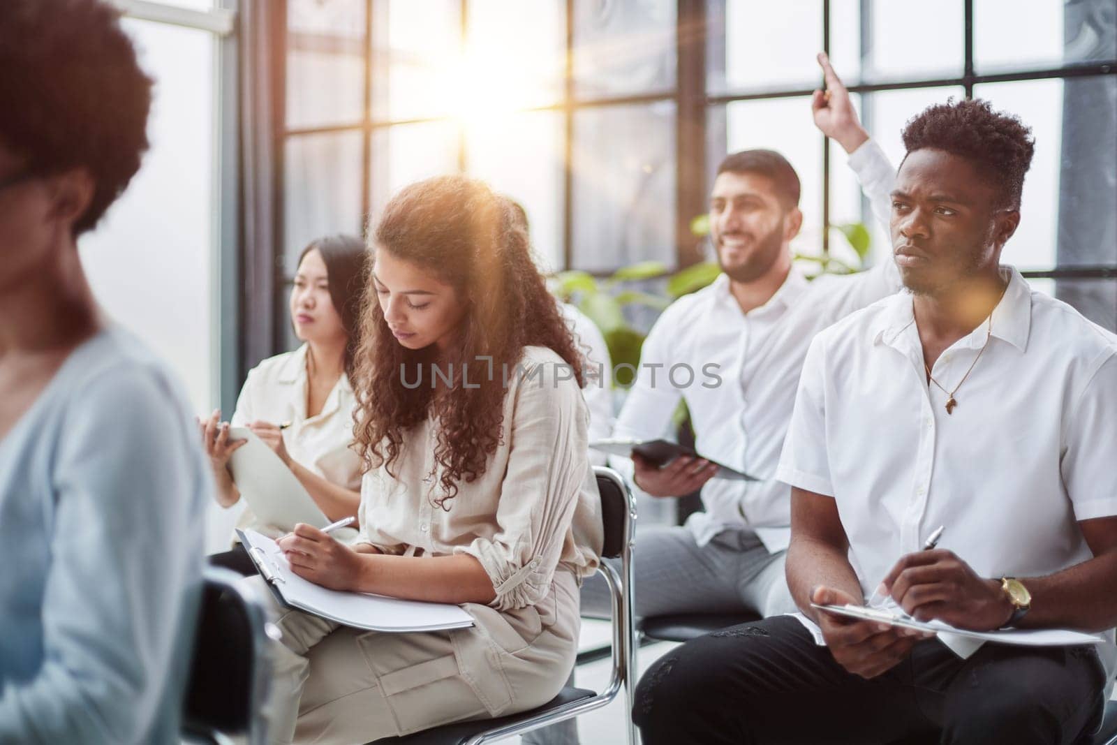 Daily meeting. A group of young people are discussing something while sitting at a table in the conference hall