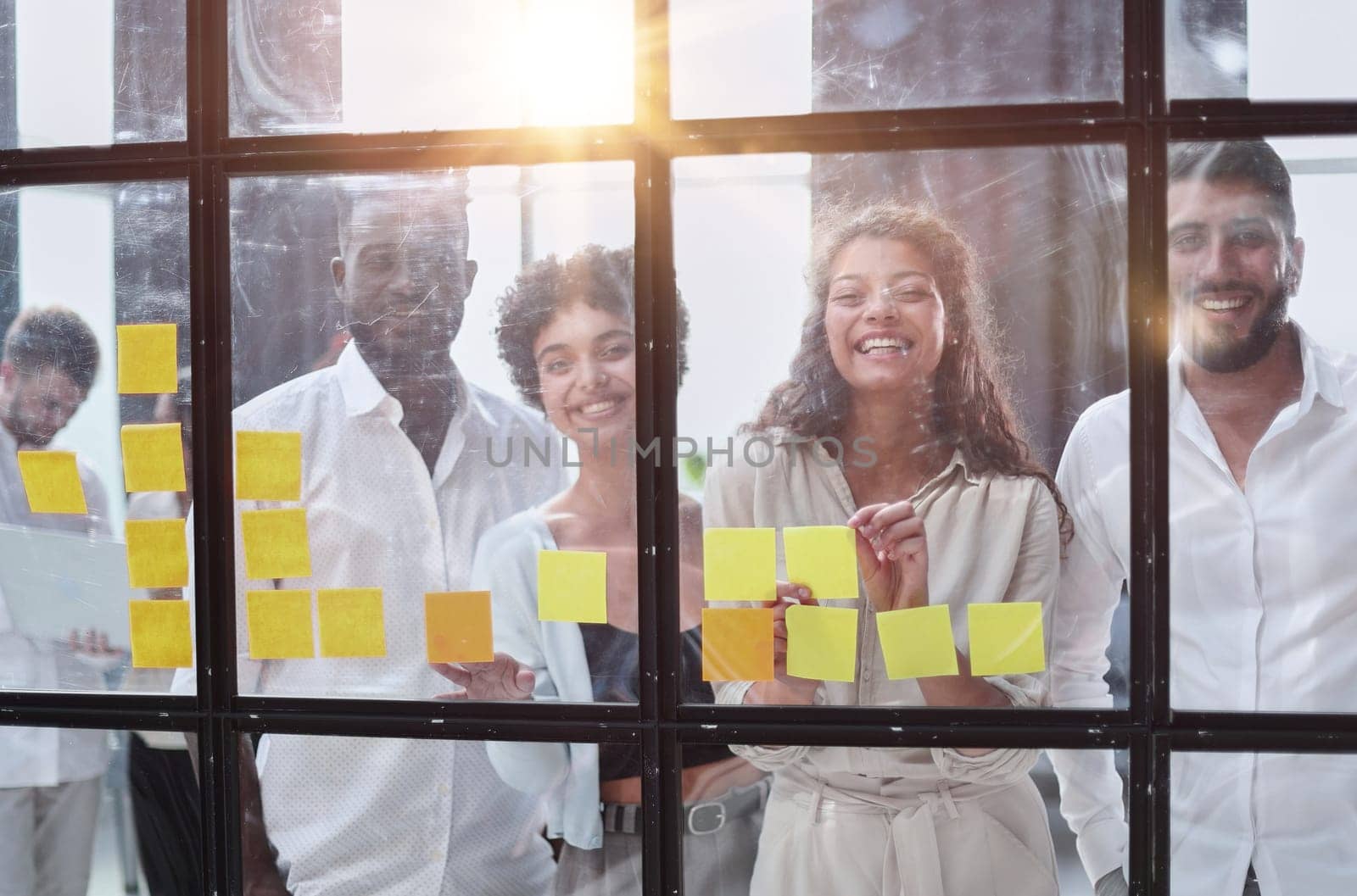 colleagues discuss and stick notes on the glass in the office