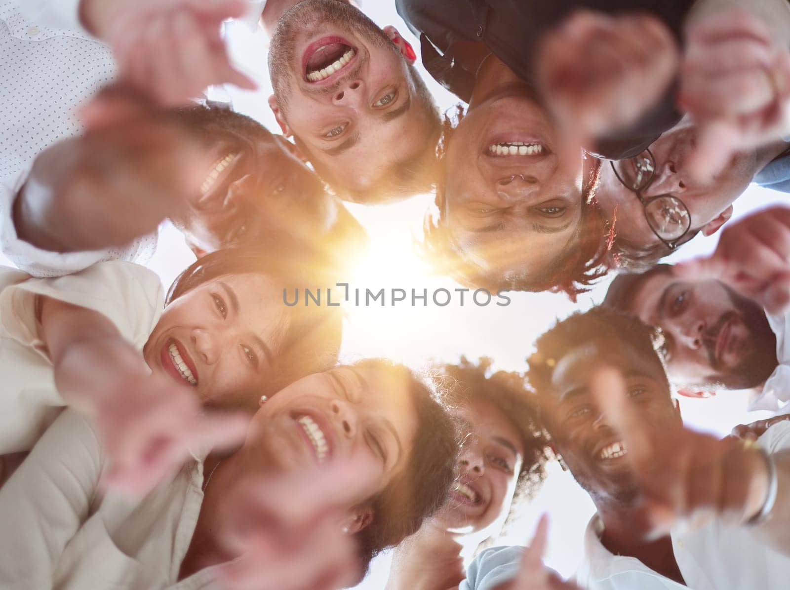group of diverse young people standing in a circle and looking down