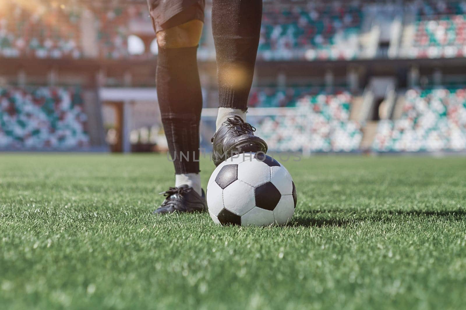 feet of soccer player tread on soccer ball in the stadium