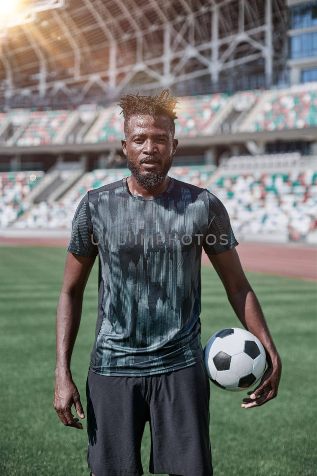 Intense portrait of a football player holding the ball in the stadium
