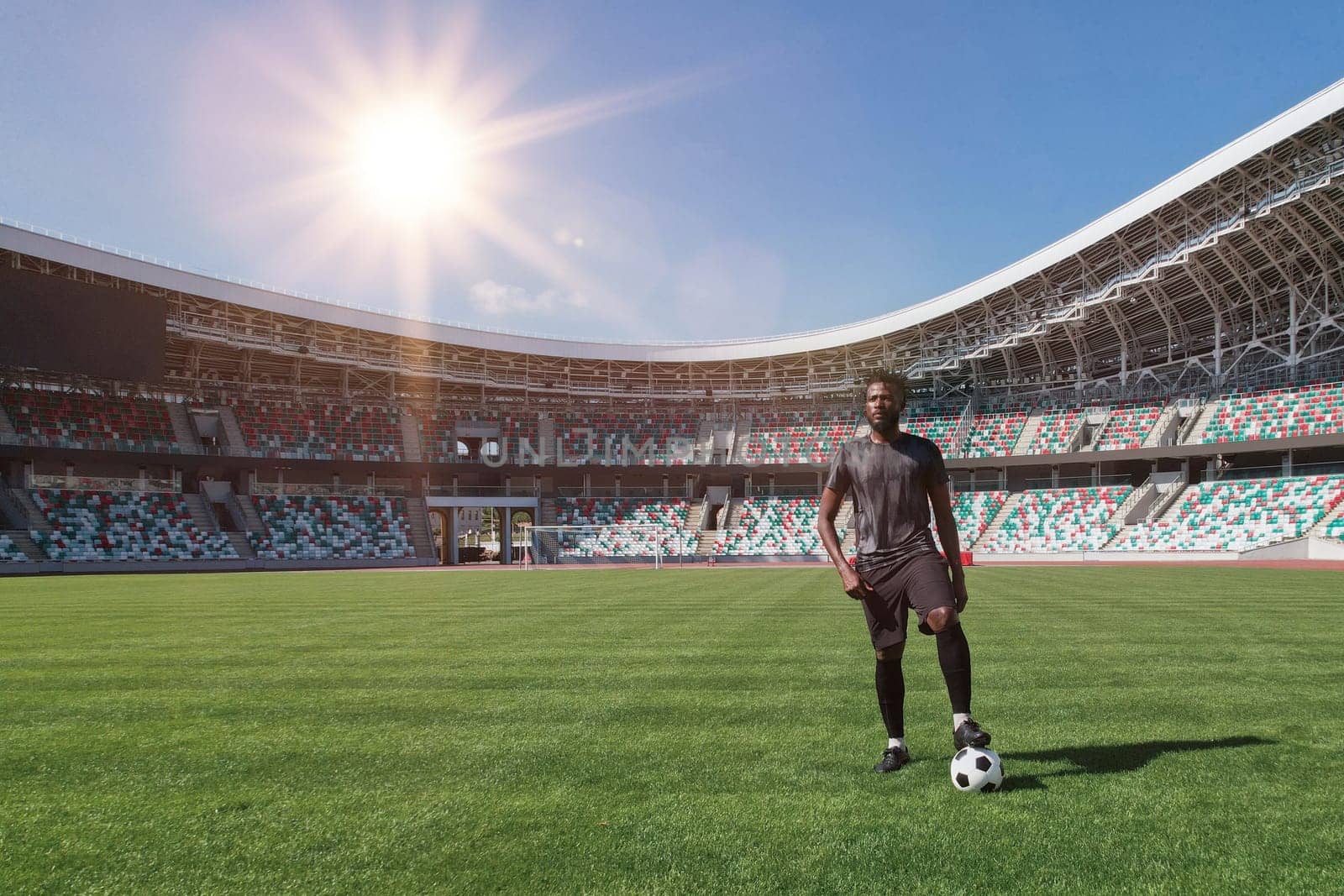 Man holding soccer ball with his foot in the stadium