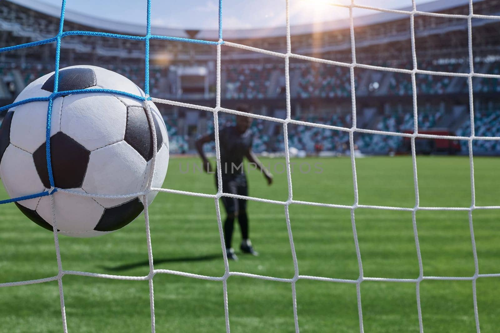 African American soccer player kicking ball inside large stadium