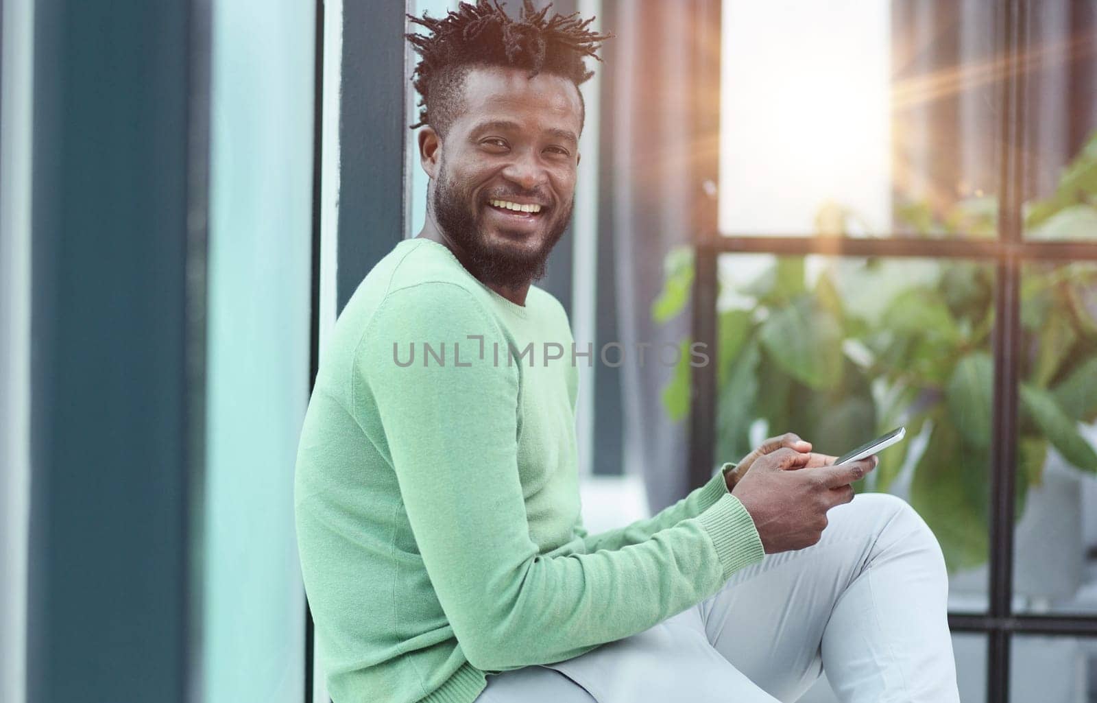 Smiling young adult african american hipster business man professional making business call talking on the phone