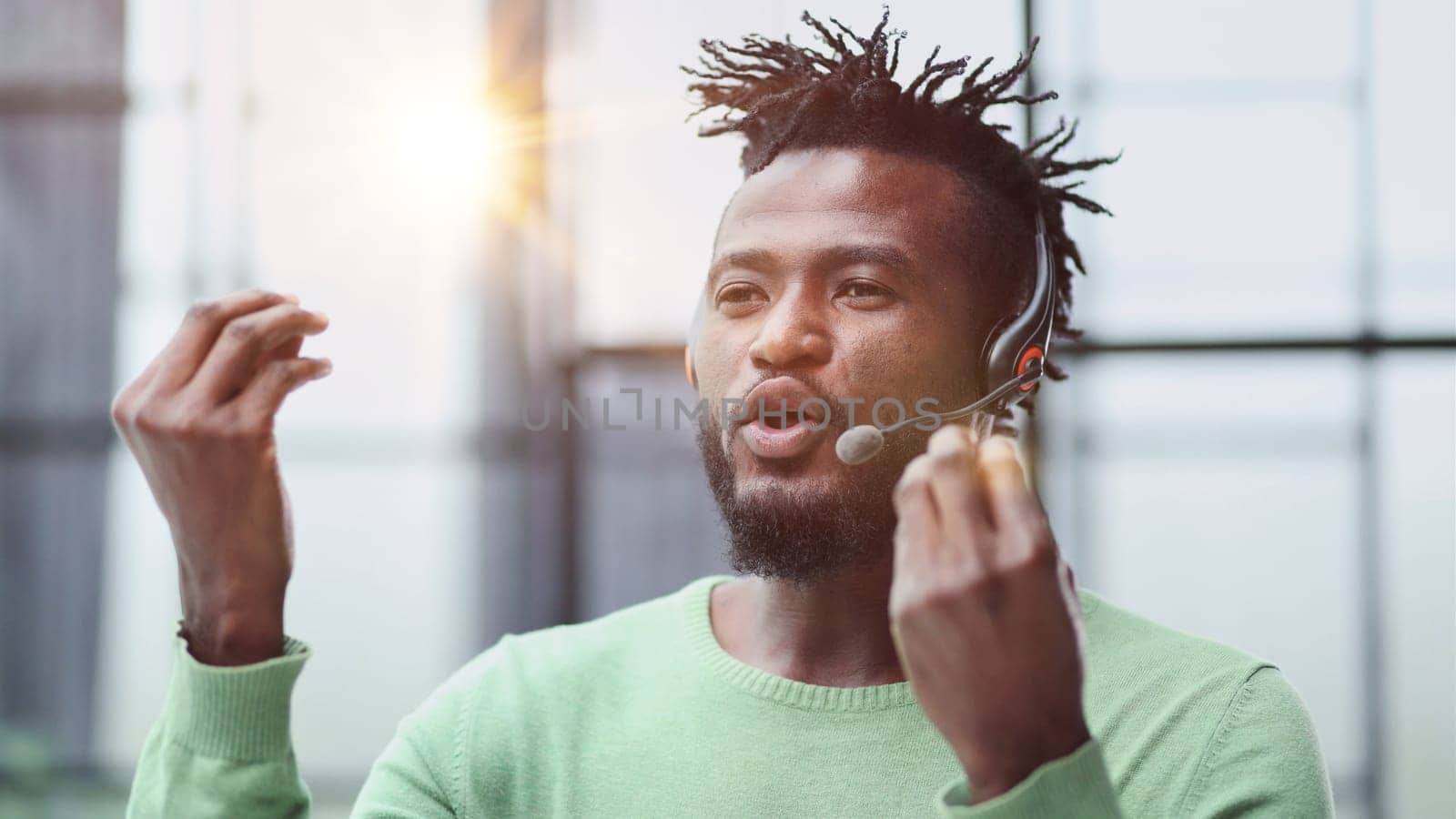 Operator of hot line. Portrait of cheerful african customer service representative with headset in call center, empty space