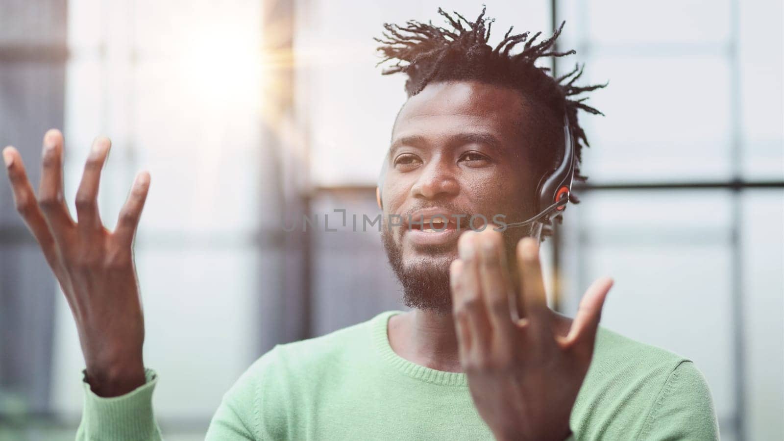 Operator of hot line. Portrait of cheerful african customer service representative with headset in call center, empty space