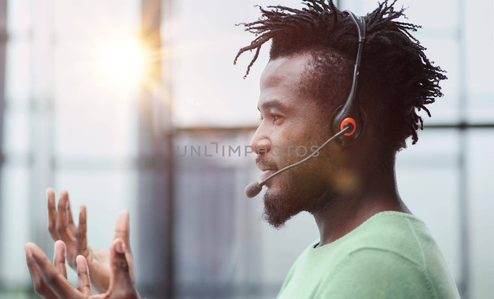 Operator of hot line. Portrait of cheerful african customer service representative with headset in call center, empty space