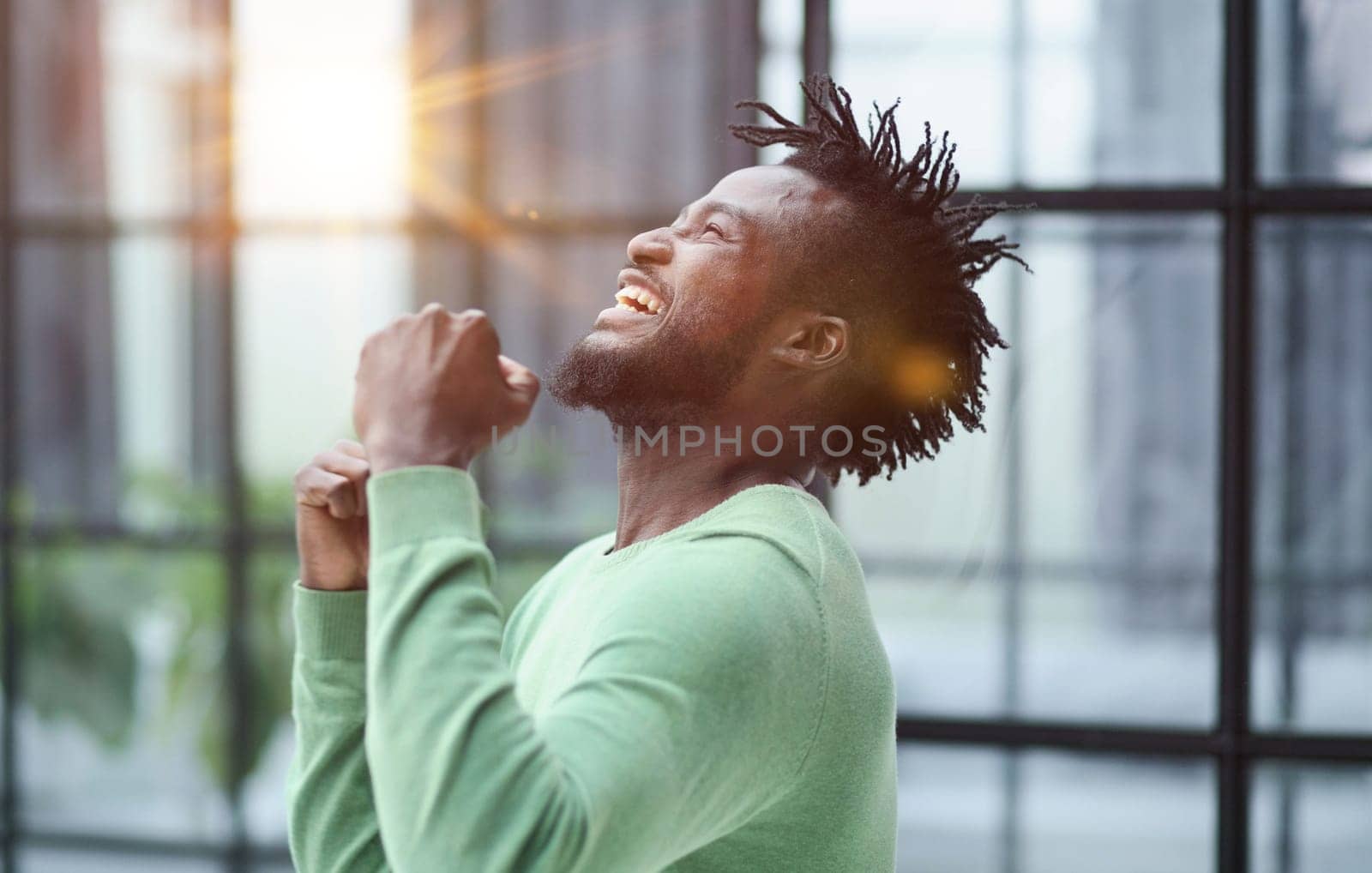 African man rejoices at the victory with his hands up