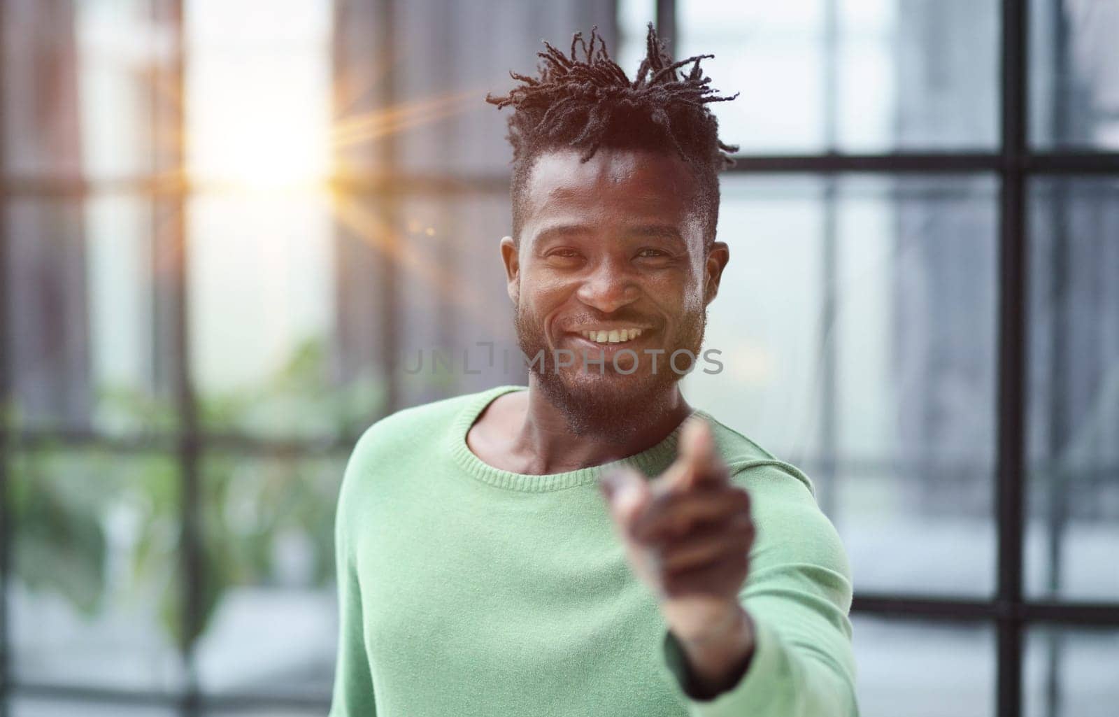 Handsome businessman pointing his finger to the camera and slicking virtual image or text. Young african american guy
