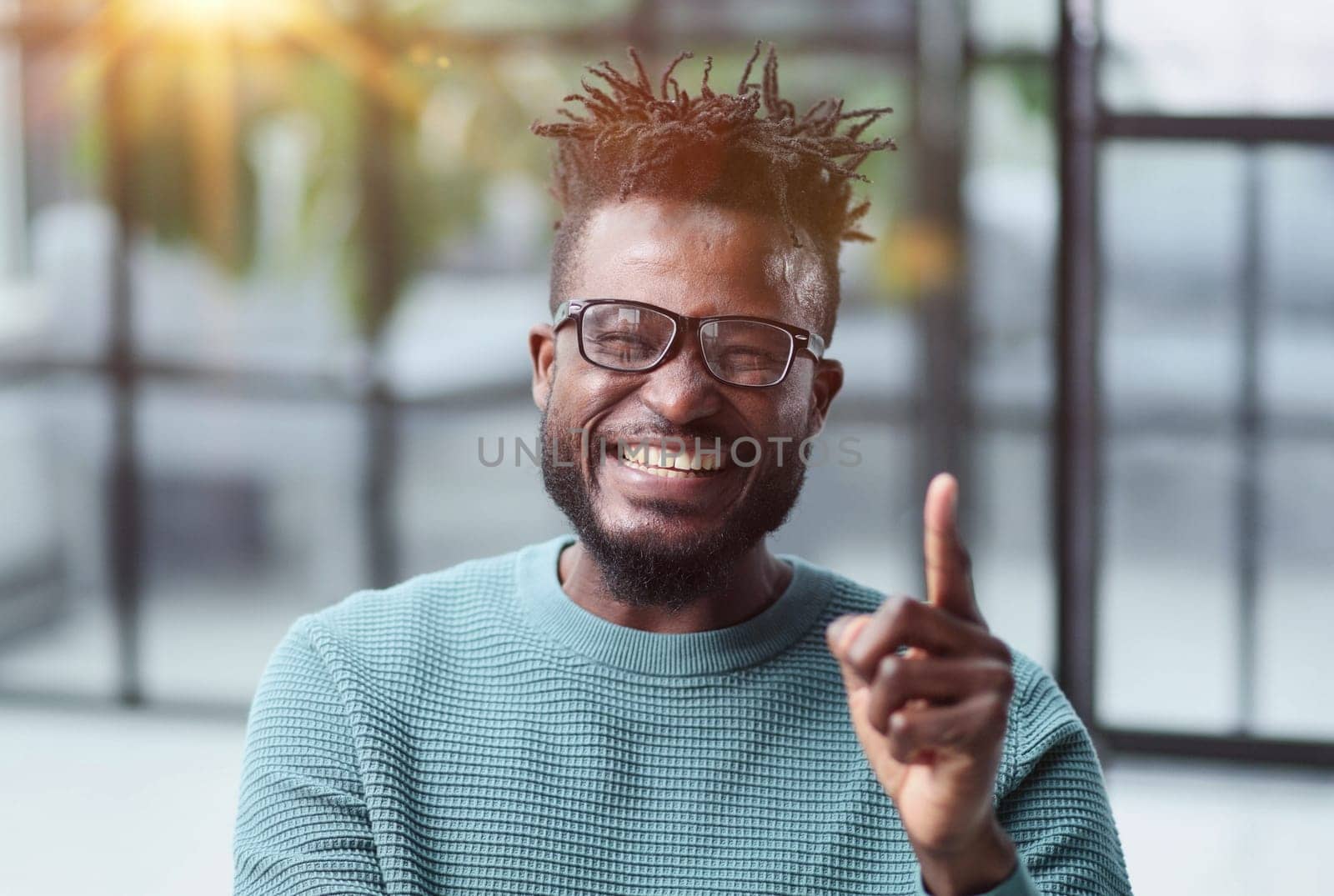 Portrait of a serious african american man, shaking his finger, warning and preventing you from something bad, looking at the camera with a worried expression.