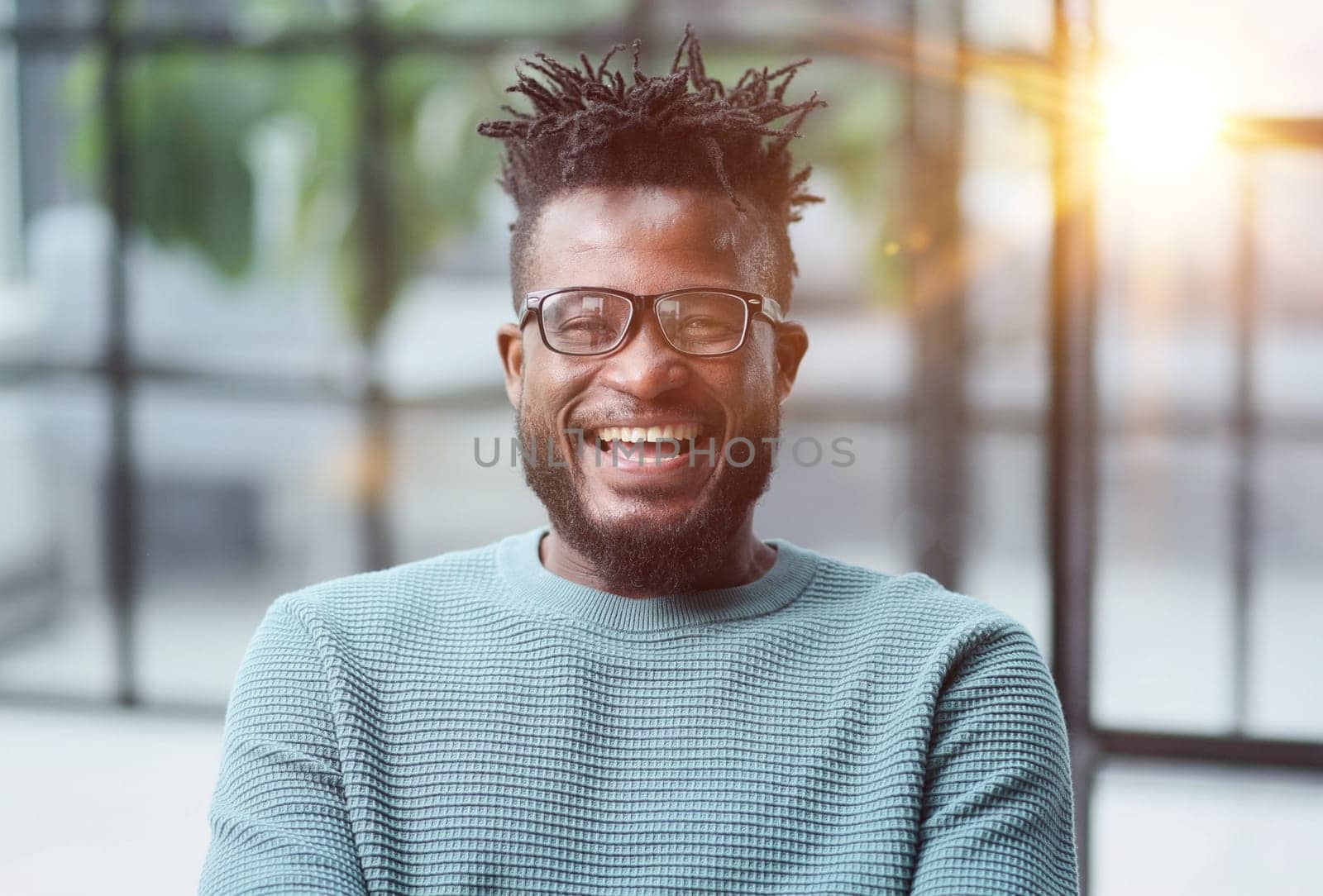 African American man in green sweater looking at camera