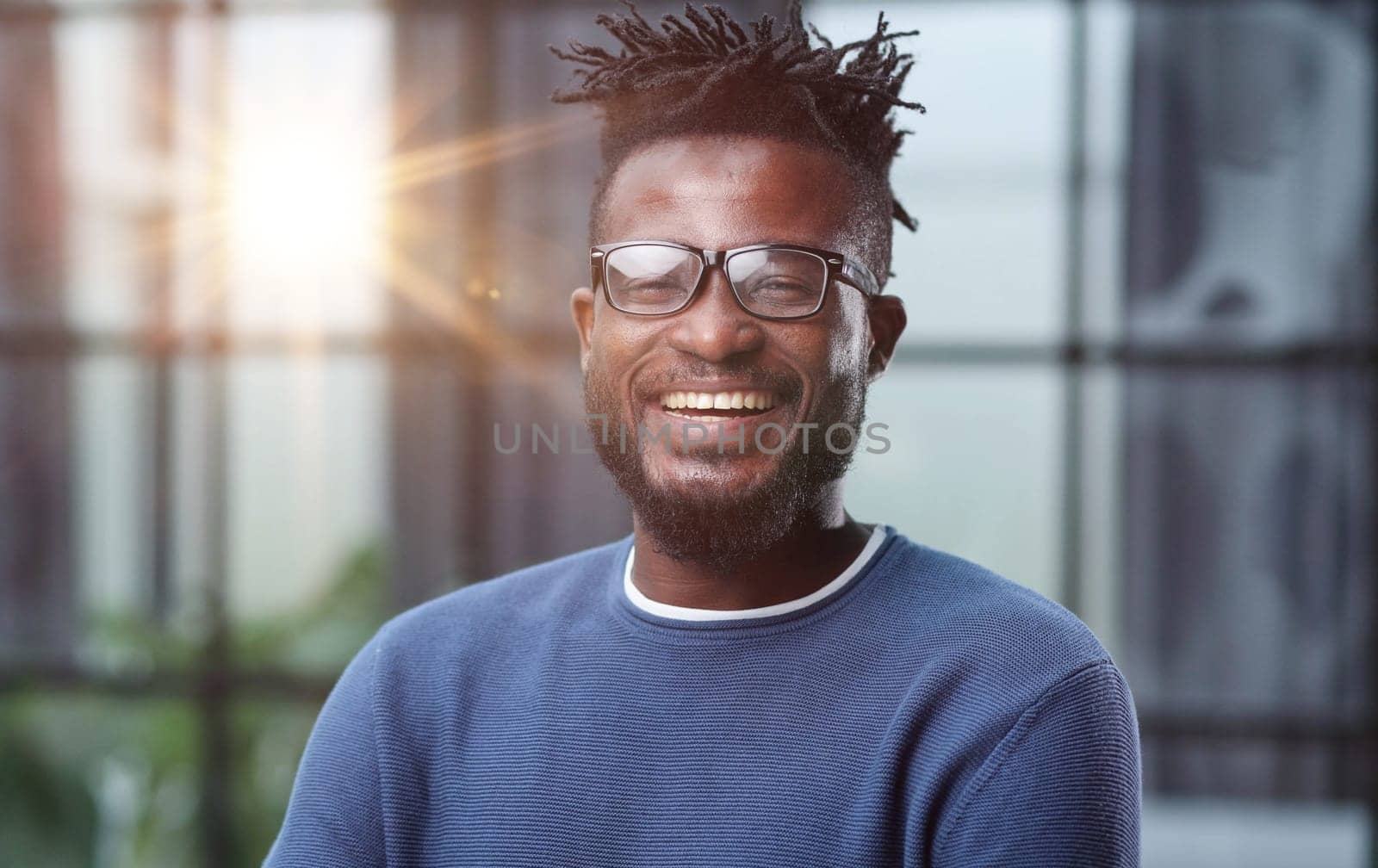 Portrait of a smiling CEO at workplace in a modern office in casual wear with glasses
