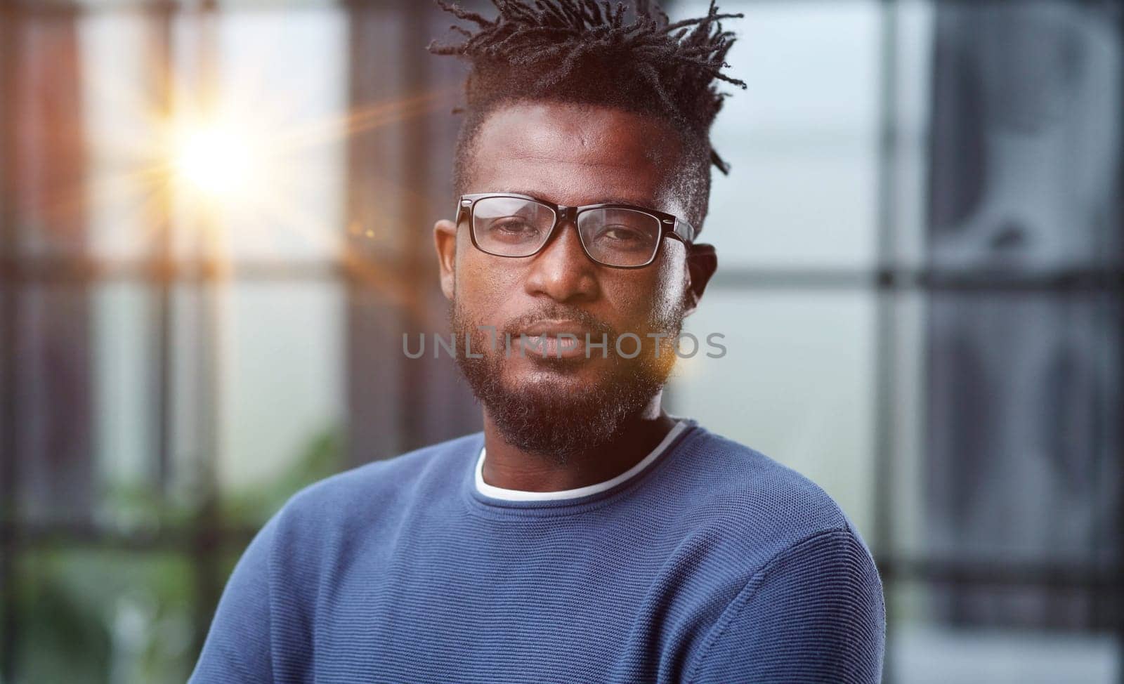 Portrait of a smiling CEO at workplace in a modern office in casual wear with glasses