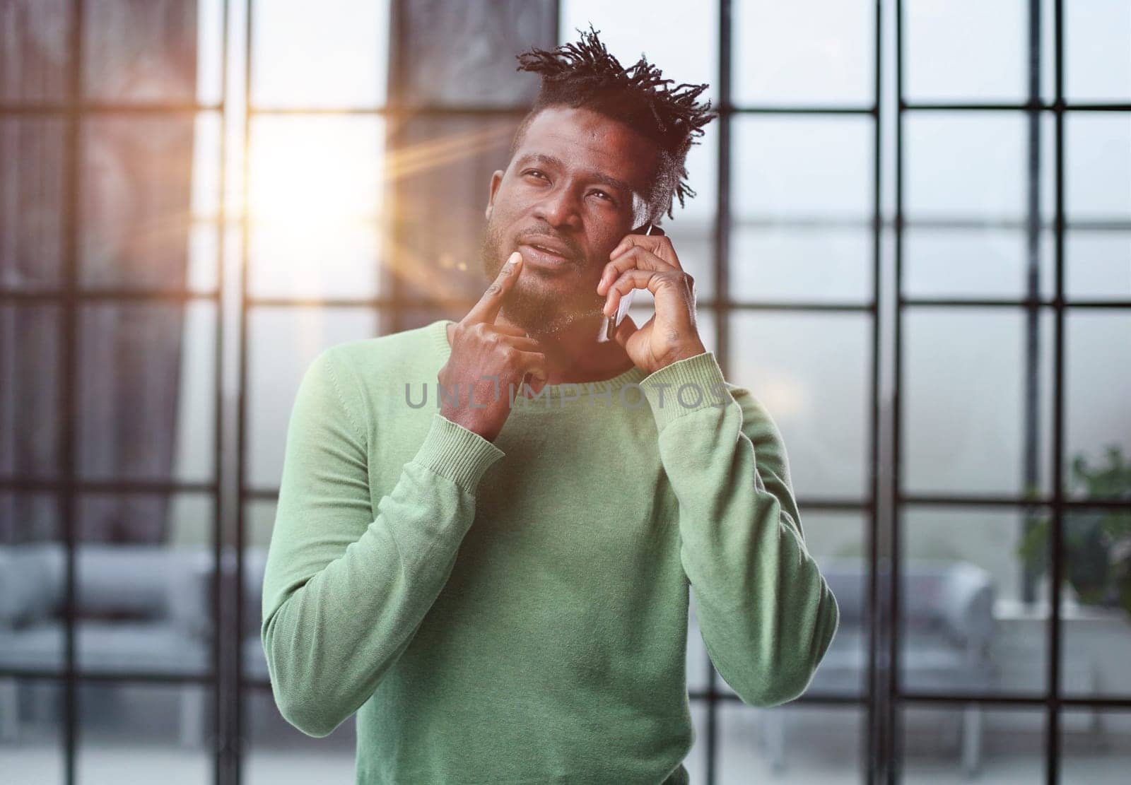 Businessman in office. Handsome man talking on phone at work.