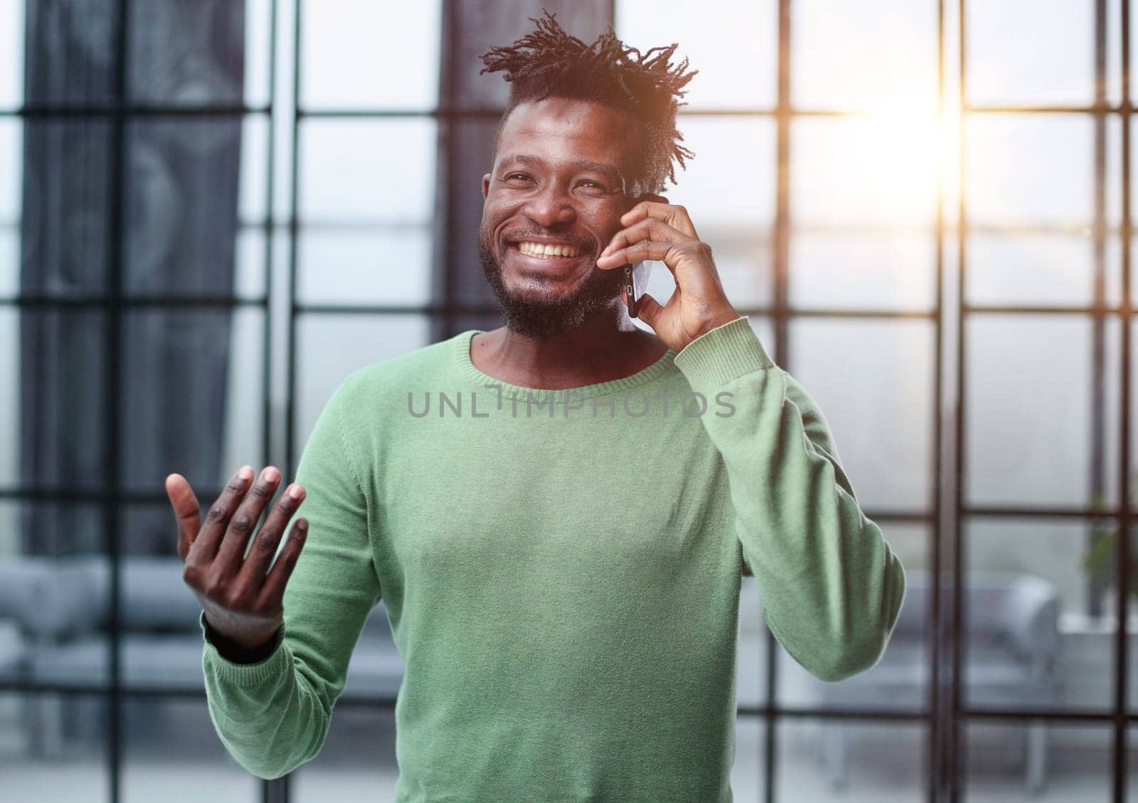 Businessman in office. Handsome man talking on phone at work.