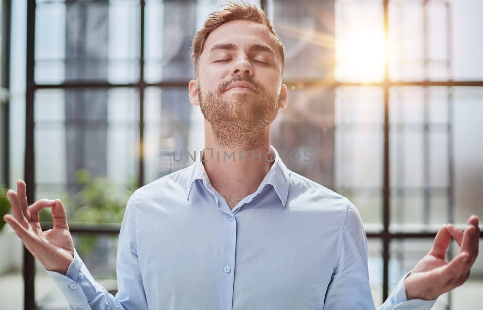 Young businessman relaxing while standing in the office