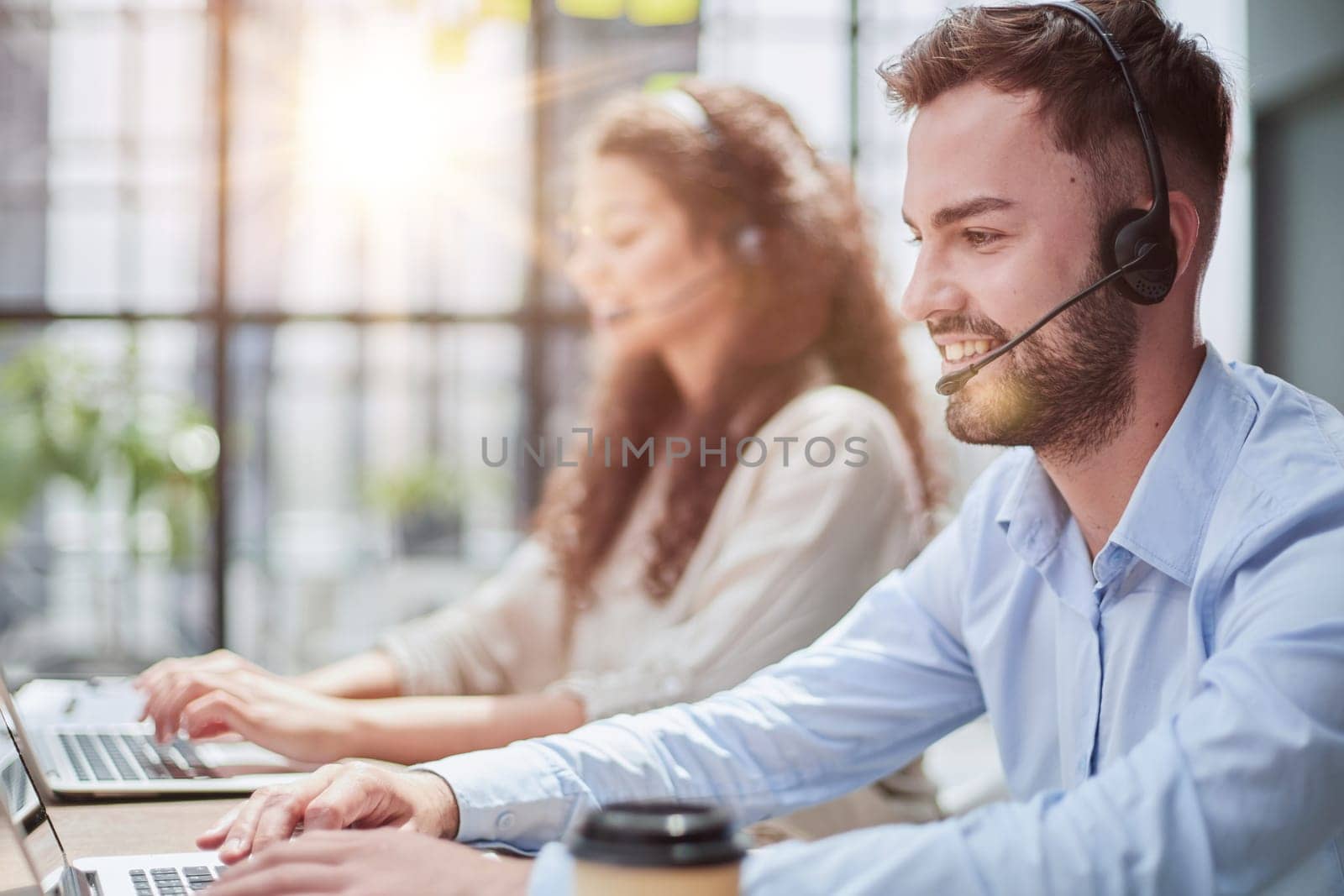 Handsome male customer service agent working in call center office as a telemarketer.