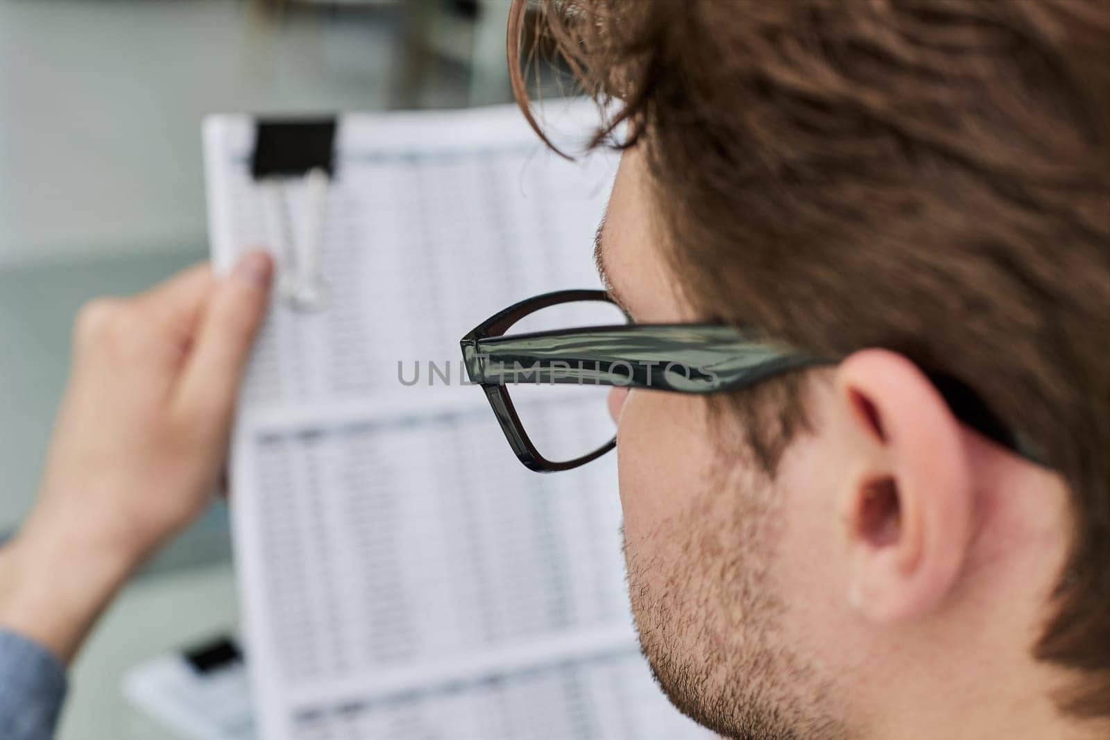 A male manager is reviewing marketing reports for the new campaign