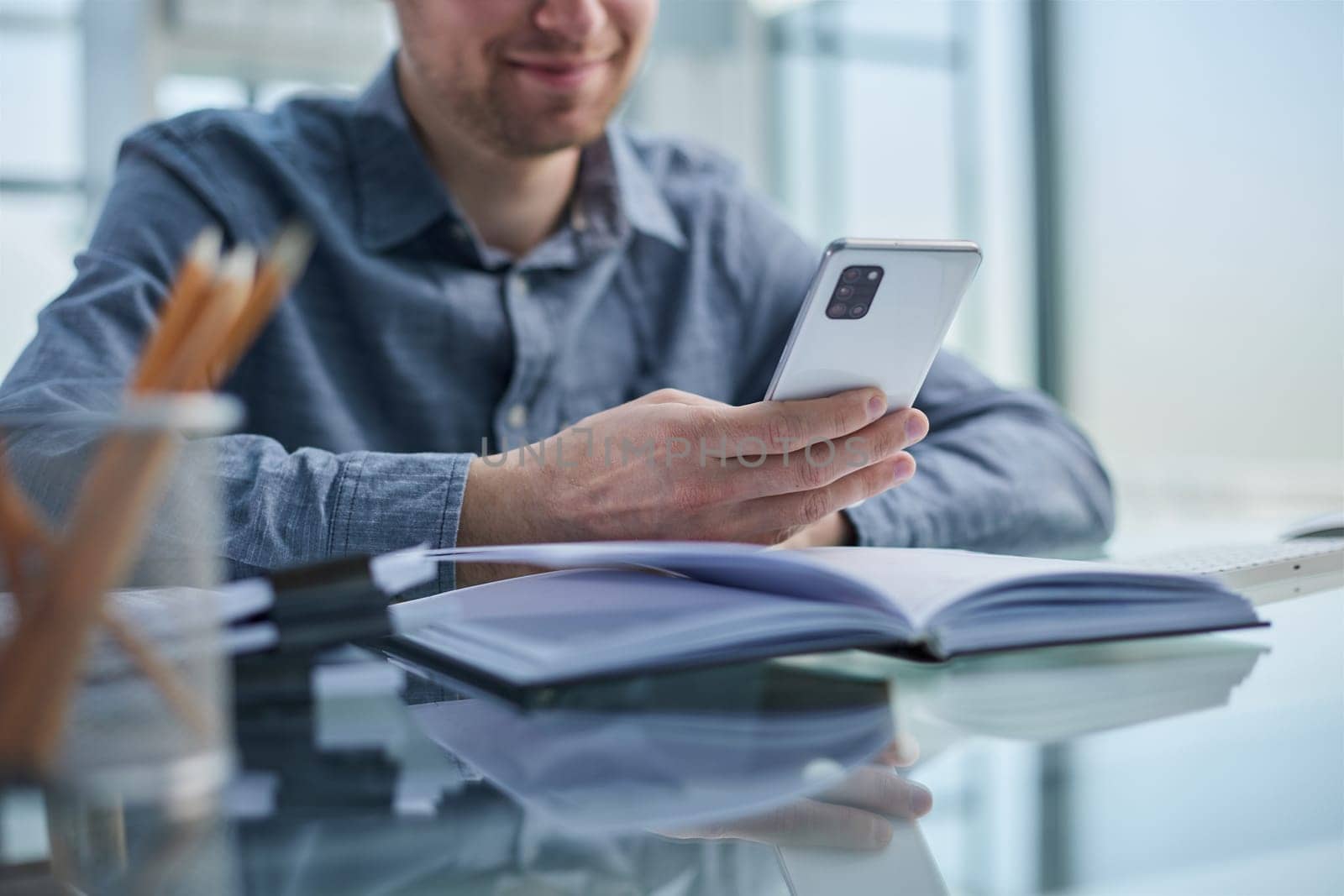 businessman professional executive holding mobile working at desk with smartphone.