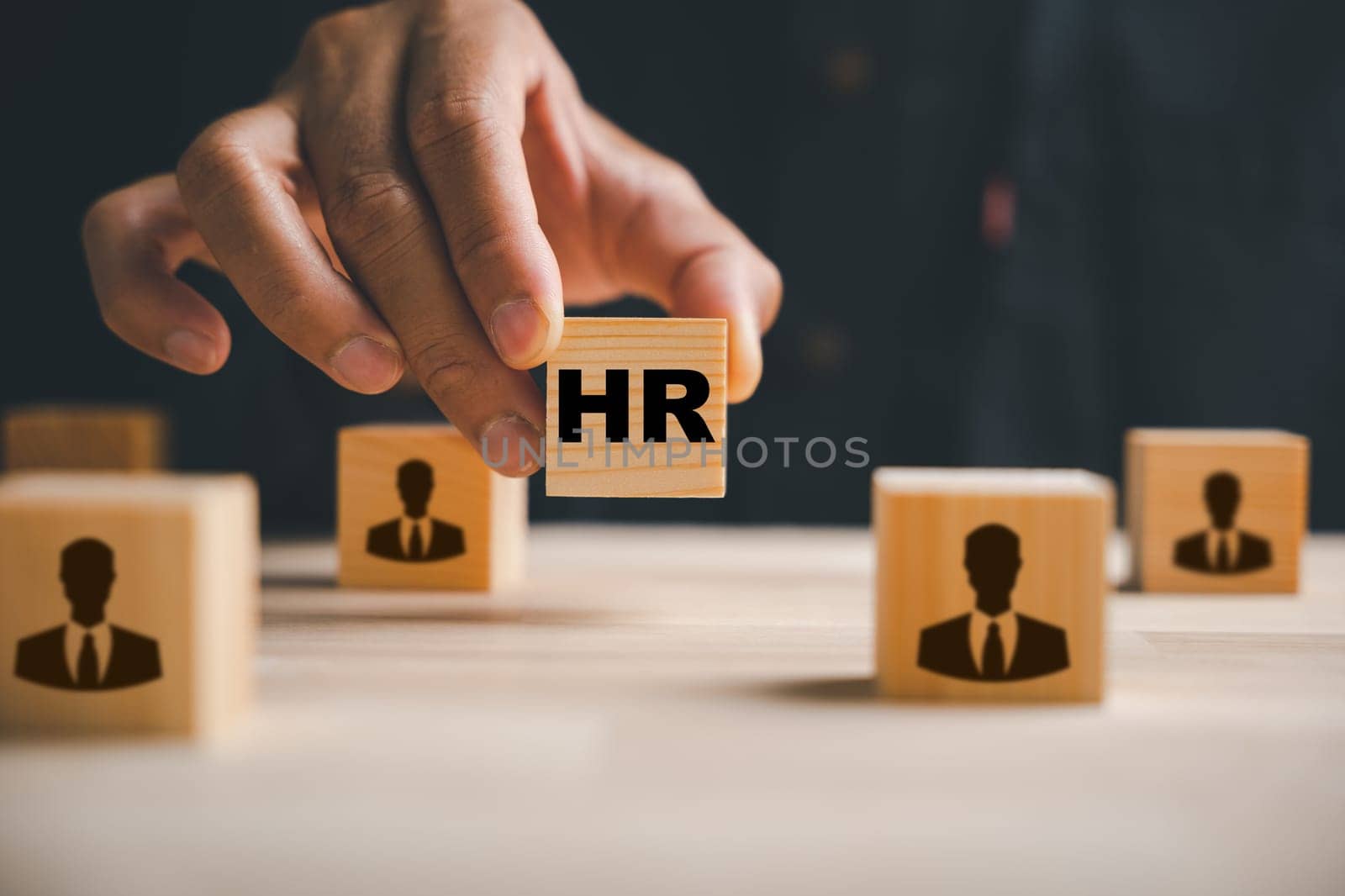 Hand selecting red human icon on wood block. Business hiring and recruitment. Career opportunity. HR Management. Leadership making crucial choices. Building a winning team. Human resource management