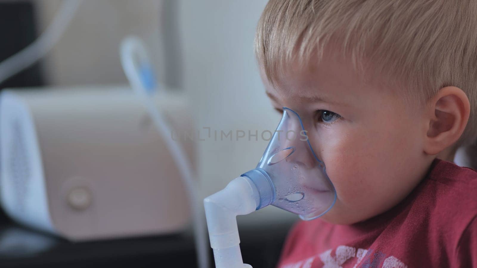 Funny boy breathing through an inhaler mask