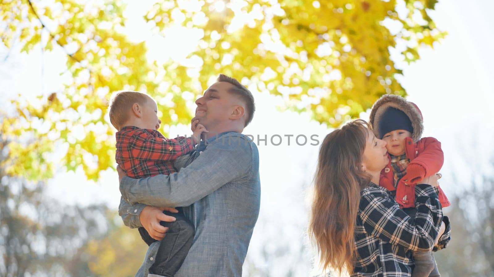 A young, funny family with kids in the park in the fall. by DovidPro