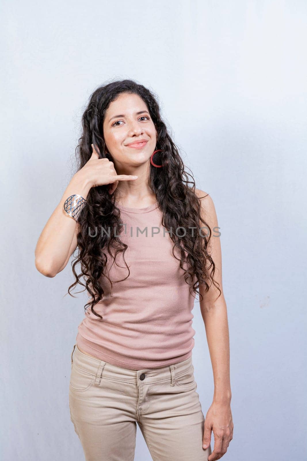 Young woman making phone gesture with fingers. Young girl making phone gesture isolated, Concept of people making phone gesture on white background by isaiphoto