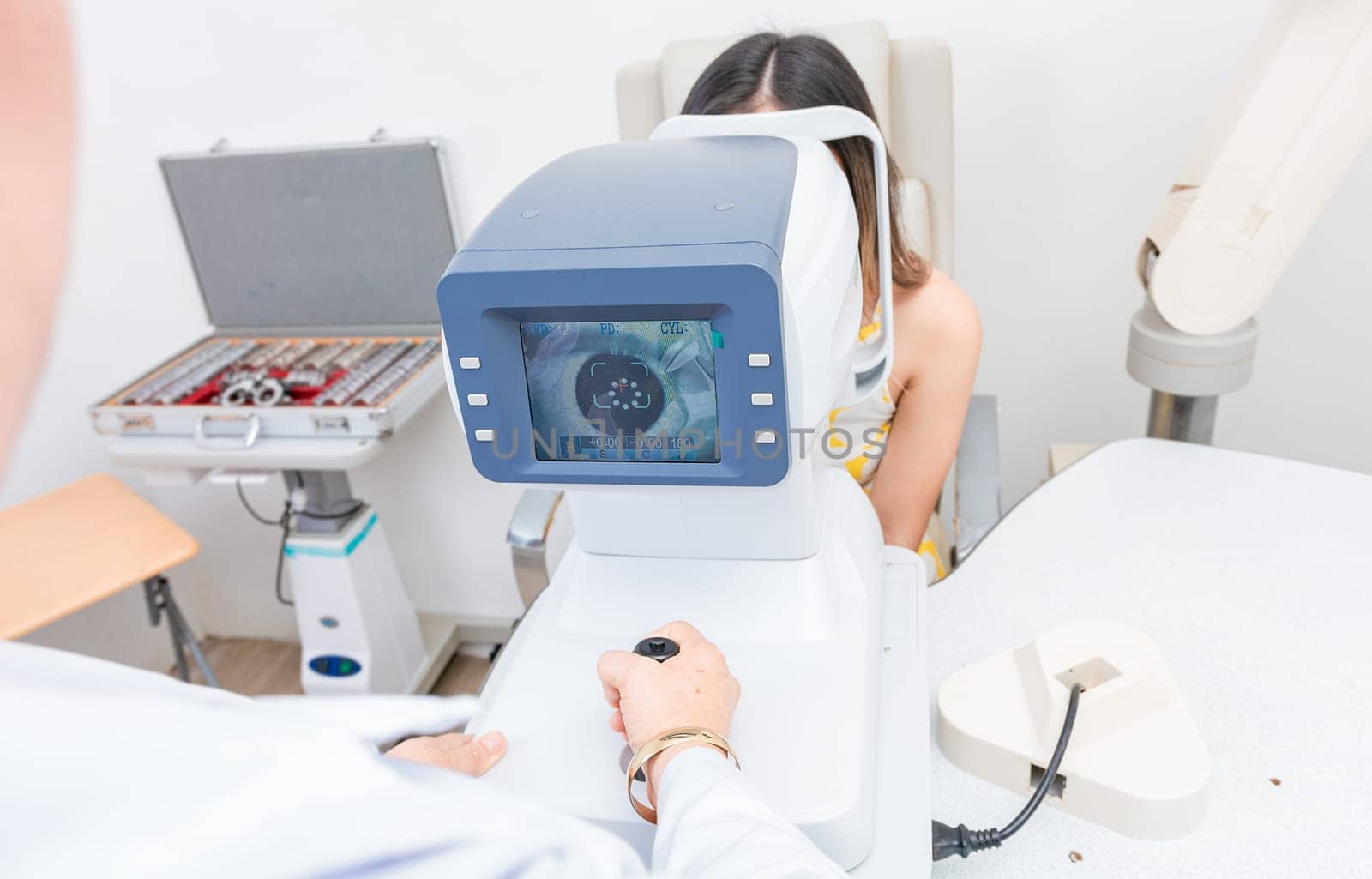 Optometrist using refractometer with patient. Eyesight of a patient on the screen of the refractometer by isaiphoto