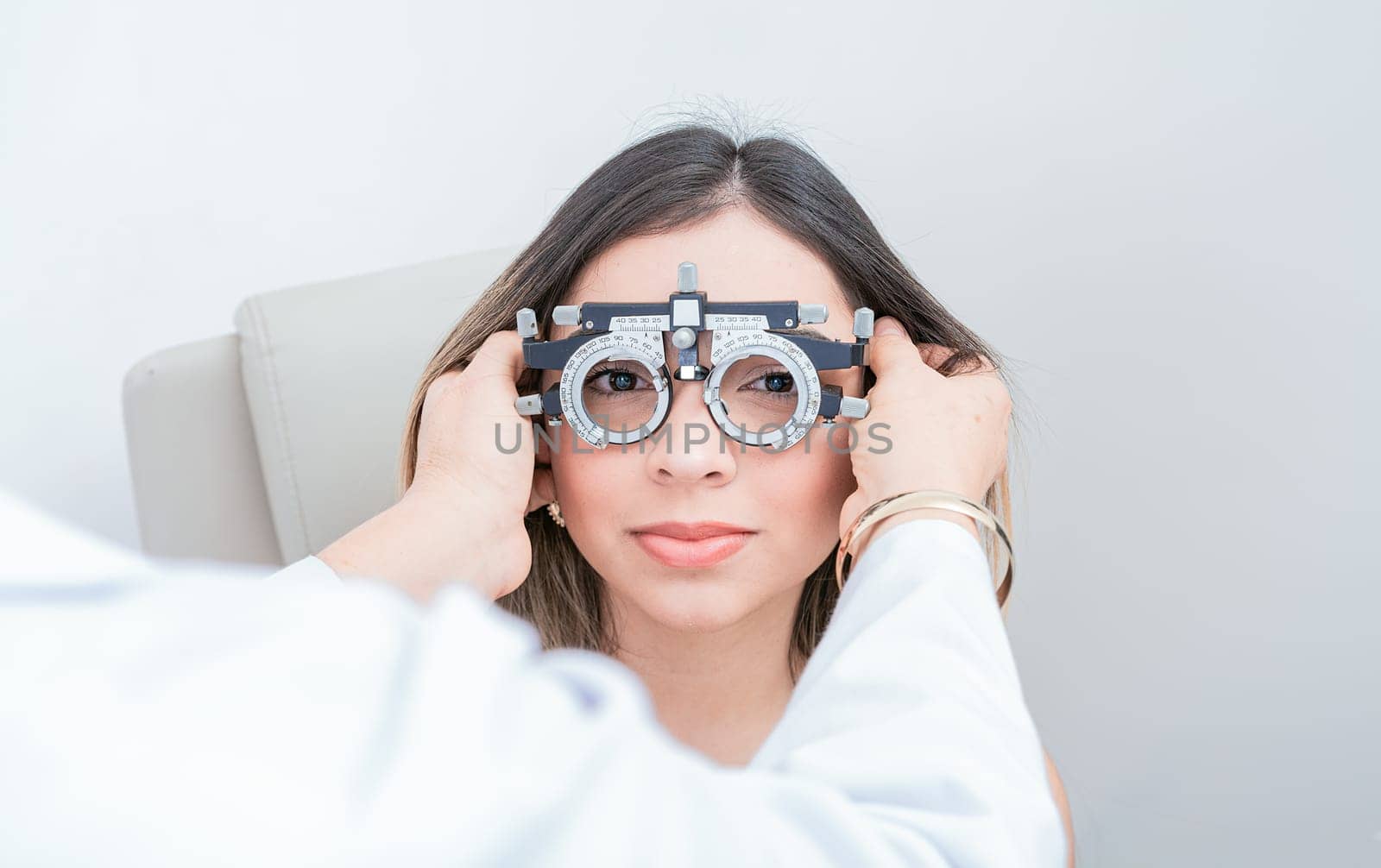 Ophthalmologist examining patient with optometrist trial frame. Doctor adjusting vision of patient with optometrist trial frame by isaiphoto