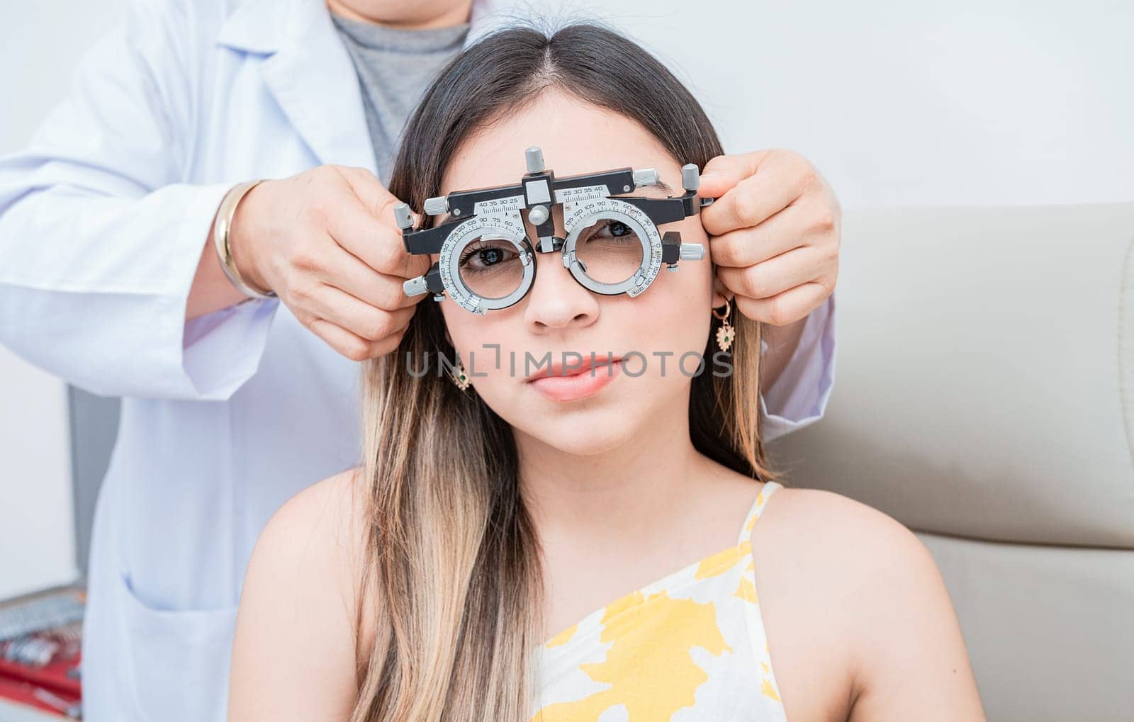 Hands of optometrist examining patient with optometrist trial frame. Young patient with optometrist trial frame